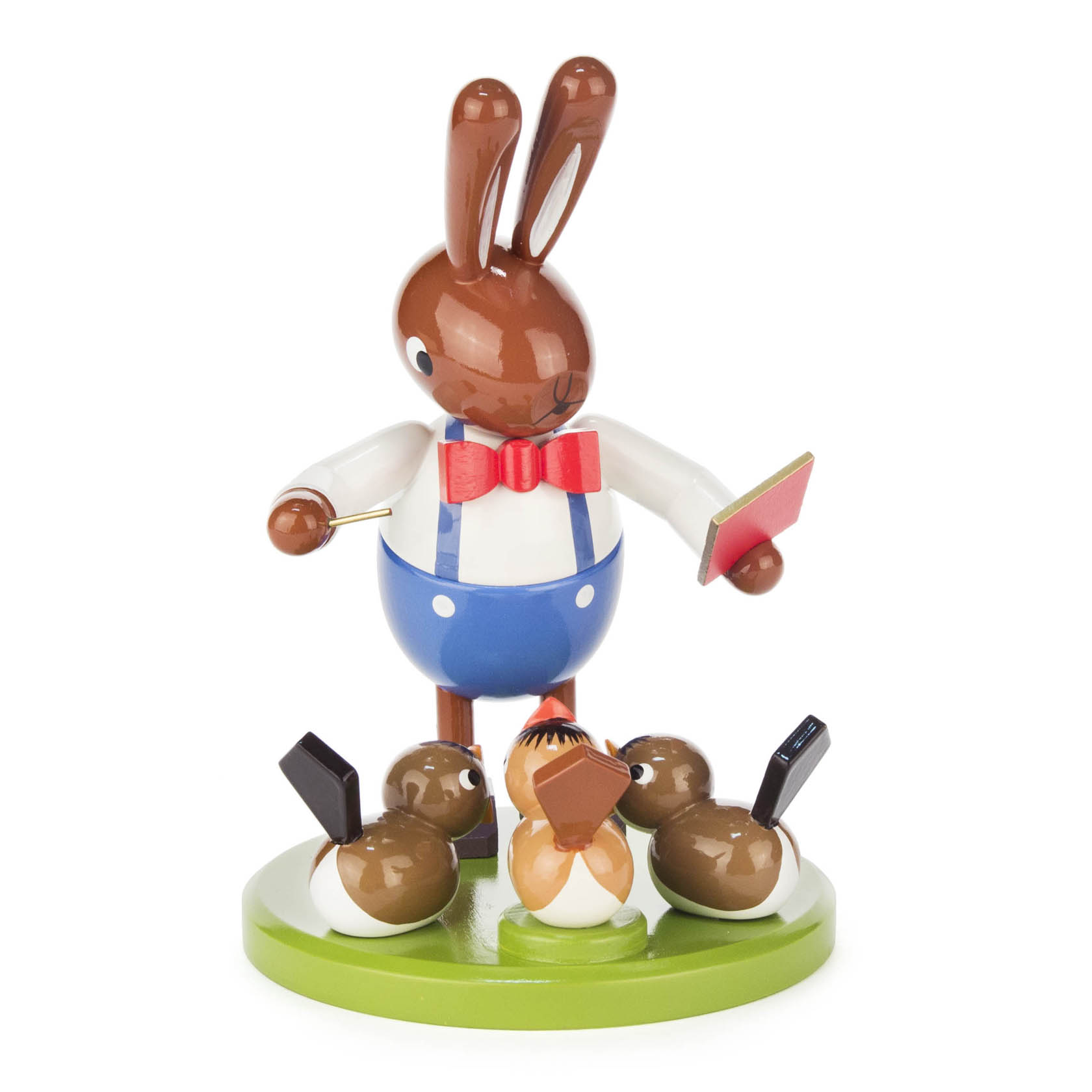 Holzfigur eines Hasen in blauer Hose, roter Fliege und weißen Hemd, der mit einem Dirigentenstab einen Chor aus drei Vögeln dirigiert. im Dregeno Online Shop günstig kaufen