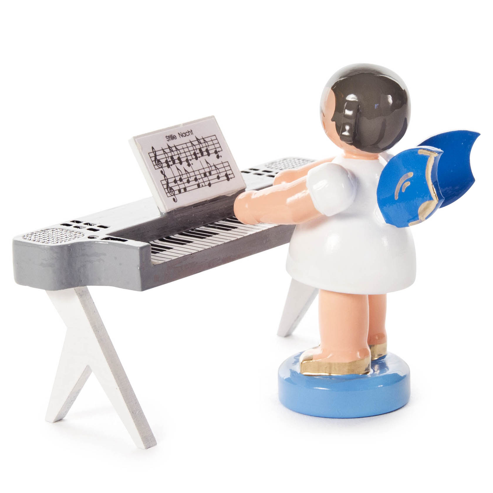 Ein Engel mit blauen Flügeln steht an einem Keyboard und spielt Noten von 'Stille Nacht'.