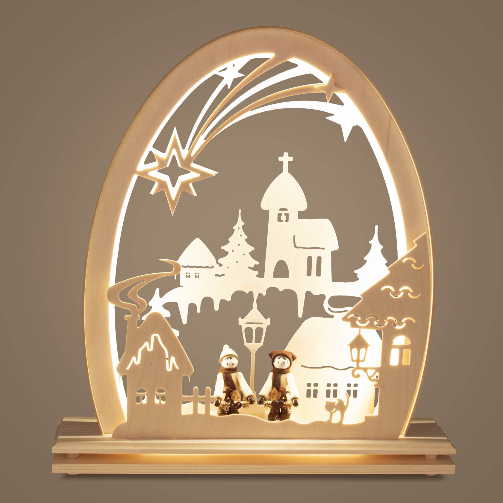 Ein elektrisch beleuchteter Erzgebirgsbogen mit LED, zeigt ein verschneites Winterdorf mit zwei kleinen Figuren, einer Kirche, Sternschweif und Tannenbaum.