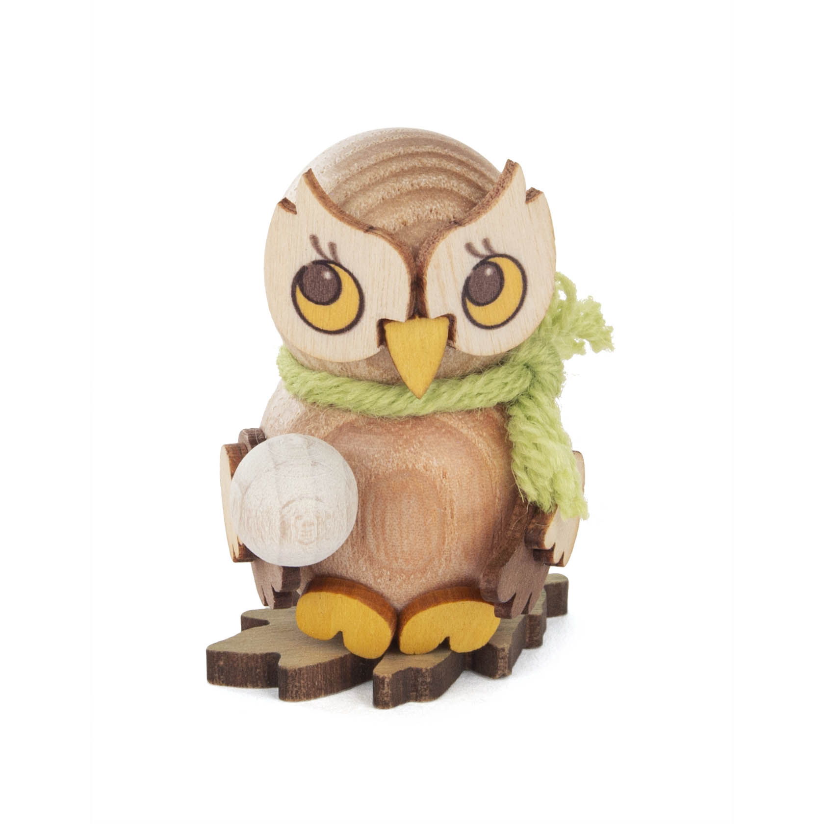 Kleine Holzfigur einer Eule mit gelbem Schnabel und grünen Schal, die eine kleine Schneekugel in einem Flügel hält. im Dregeno Online Shop günstig kaufen