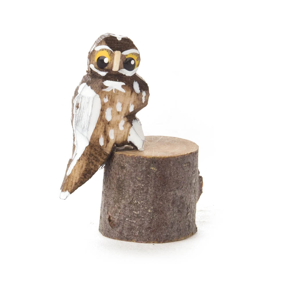 Kleine bemalte und gebeizte Eule sitzt auf einem Baumstamm. Die Eule hat gelbe Augen und weiße, braune sowie schwarze Details auf den Flügeln und Brust. im Dregeno Online Shop günstig kaufen