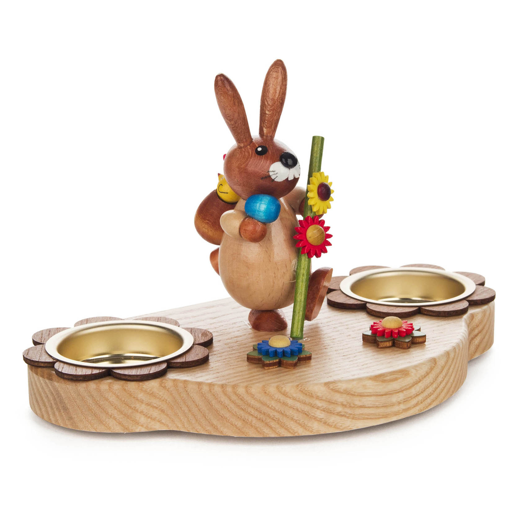 Teelichthalter aus Holz in Naturfarben mit einem Hasenfigur, der einen Wanderstab hält. Zwei Teelichthalter in Blumenform auf dem Holzsockel.