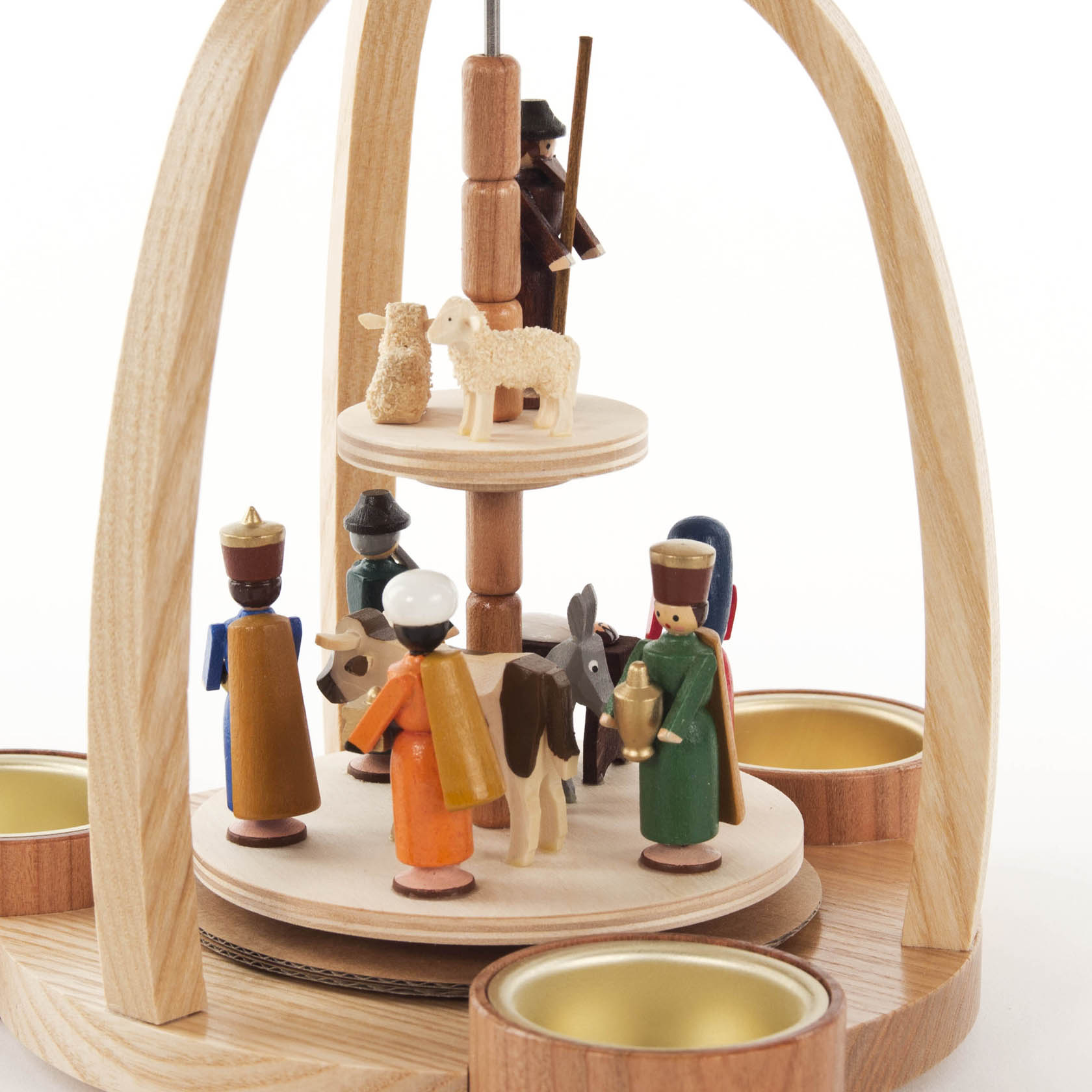 Holzpyramide mit bunten Holzfiguren der Geburt Christi. Figuren sind Heilige Drei Könige, Joseph, Maria, ein Schaf und ein Hirte. Teelichtschalen an der Basis.
