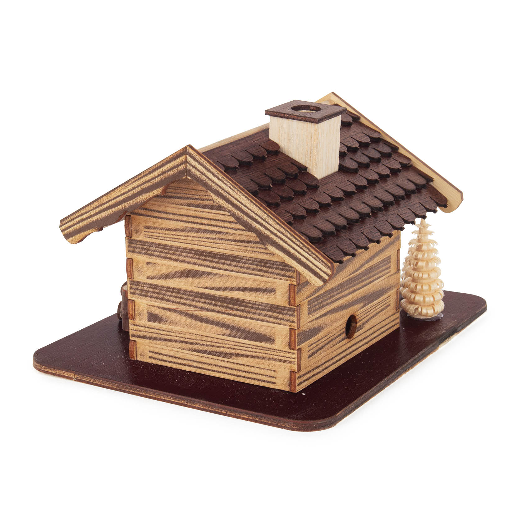 Holzhandwerk dargestellt als Räucherhaus 'Waldhaus' mit einem Holzmacher, der Holz hackt, zwei kleine Tannenbäume daneben.