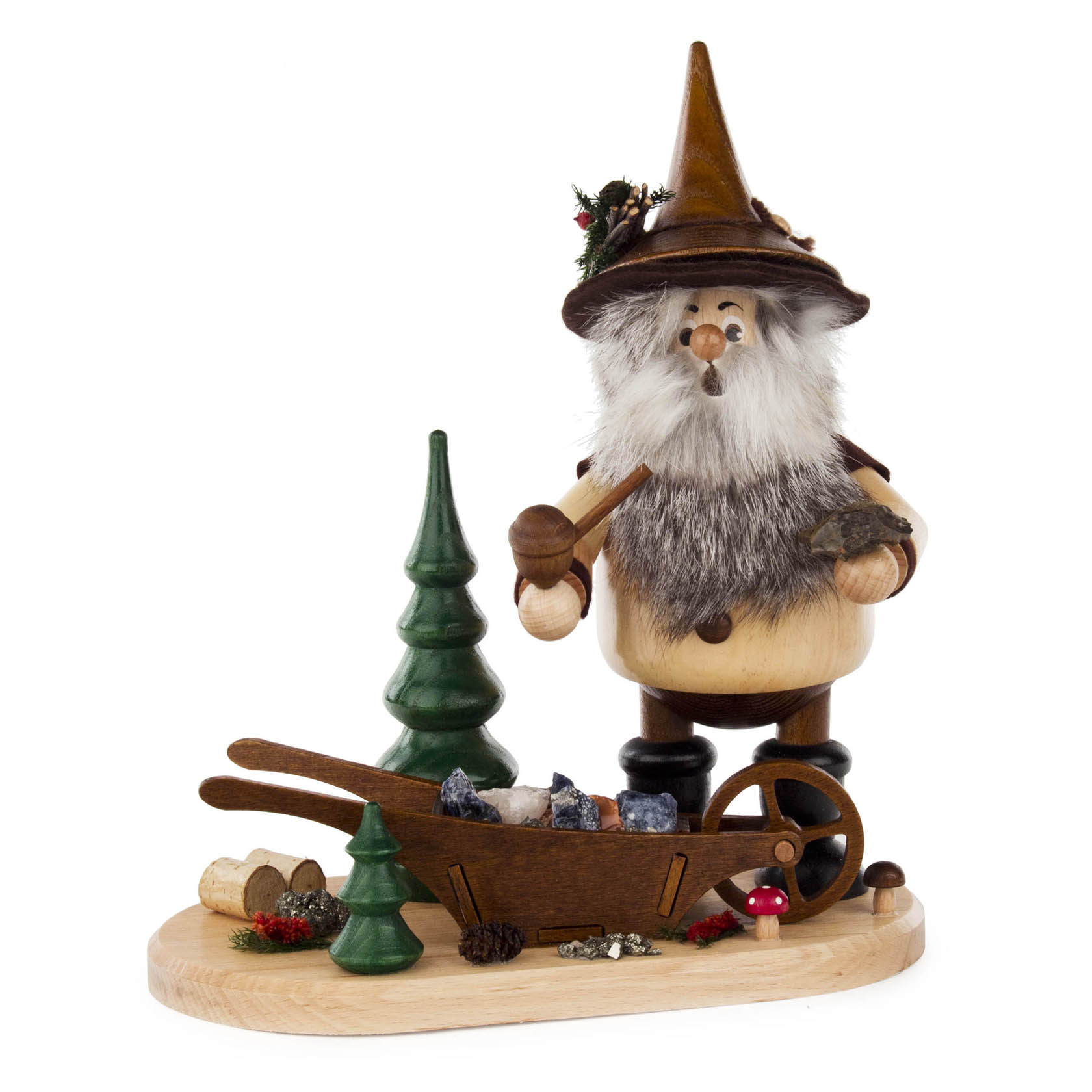 Räuchermann als Erzwichtel mit Spitzhut, Fellbart und einem Pfeifchen. Er steht neben einer Erzkarre und kleinen Deko-Tannenbäumen auf holzfarbener Basis. im Dregeno Online Shop günstig kaufen