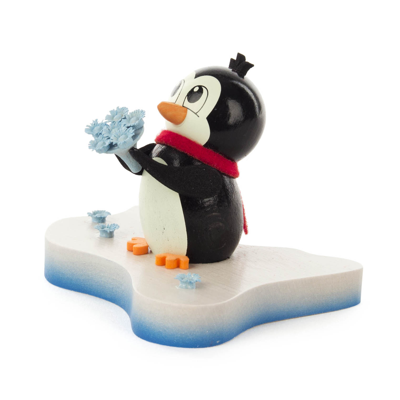Eine niedliche Pinguinfigur hält blaue Blumen in den Flossen. Der Pinguin trägt einen roten Schal und steht auf einer eisähnlichen Plattform.