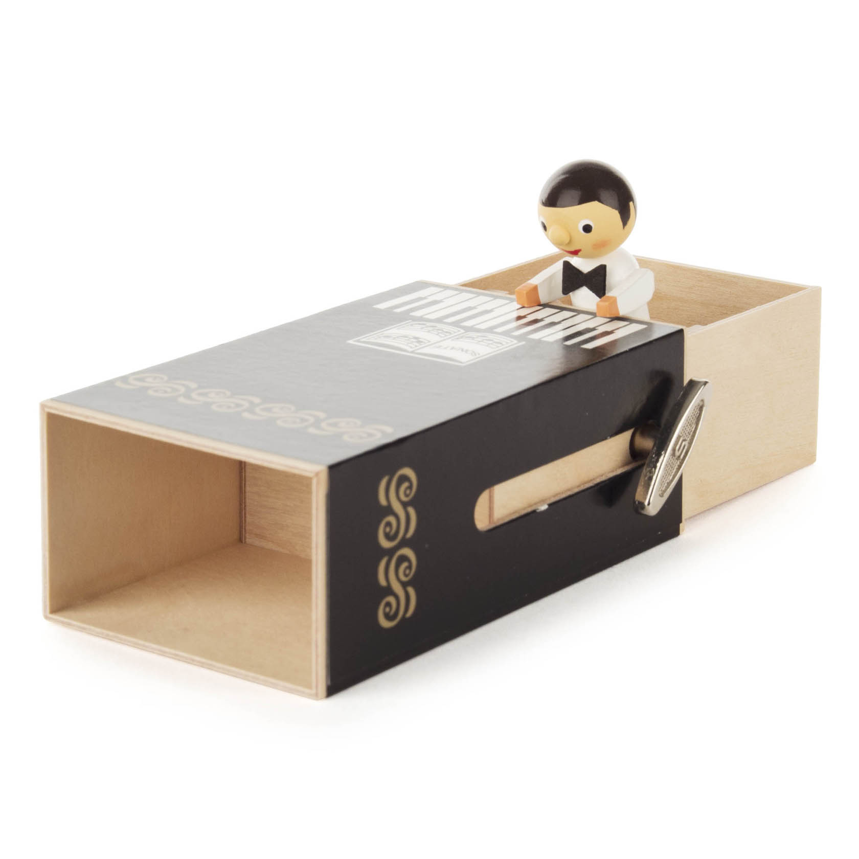 Eine Schiebebox im Klavier-Design mit einer kleinen Figur eines Jungen im Frack, der auf einer Miniaturen-Tastatur spielt.