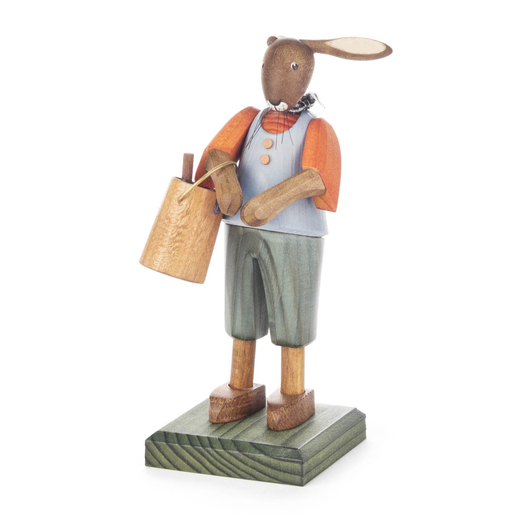 Eine Holzfigur eines Hasen in bunter Kleidung, mit orangefarbenem Shirt und grünen Hosen, hält einen hölzernen Farbeimer. Der Hase steht auf einem kleinen Sockel. im Dregeno Online Shop günstig kaufen