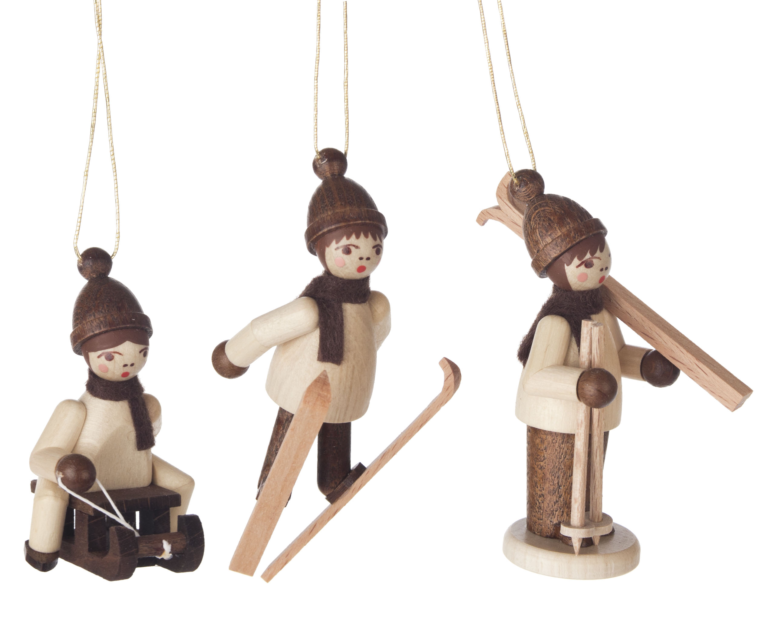 Drei hölzerne Figuren von Kindern, die Winteraktivitäten nachgehen: Skifahren, Schlitten ziehen und Skifahren mit Stöcken. Alle tragen braune Mützen und Schals.
