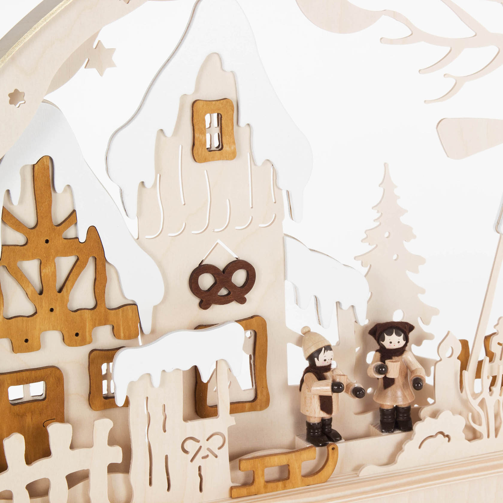 Holzschwibbogen mit zwei Kindern in Winterkleidung. Im Hintergrund ein festlich dekoriertes Holzhaus mit einem großen Brezel-Symbol.