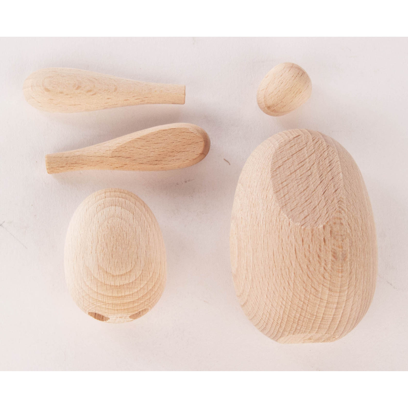 Ein Bastelset aus Holz bestehend aus fünf Teilen: einem ovalen Körper, einem kleinen Kopf, zwei langen Ohren und einem kleinen ovalen Element.