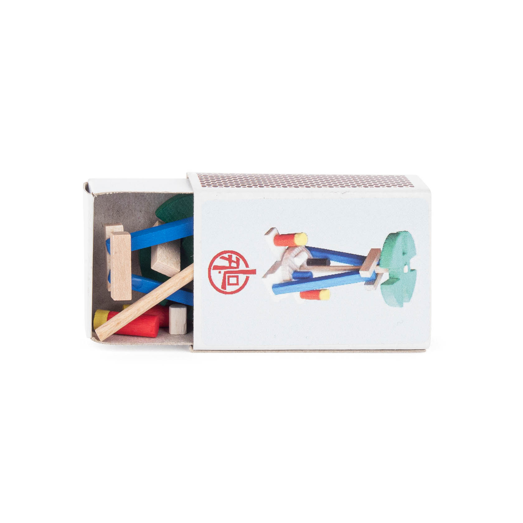Geöffnete Zündholzschachtel mit kleinen Holzbauteilen in verschiedenen Farben und Formen, die zusammen eine miniaturisierte Weihnachtspyramide ergeben.
