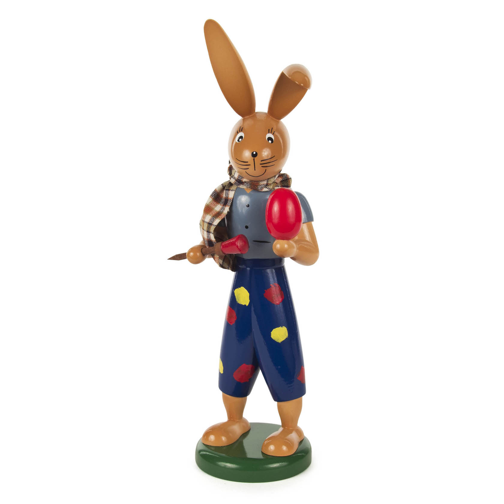 Holzfigur eines Hasenmalers mit Pinsel in der rechten Hand, rotem Osterei in der linken Hand, einem karierten Schal, blauen Hosen und farbigen Tupfen. im Dregeno Online Shop günstig kaufen