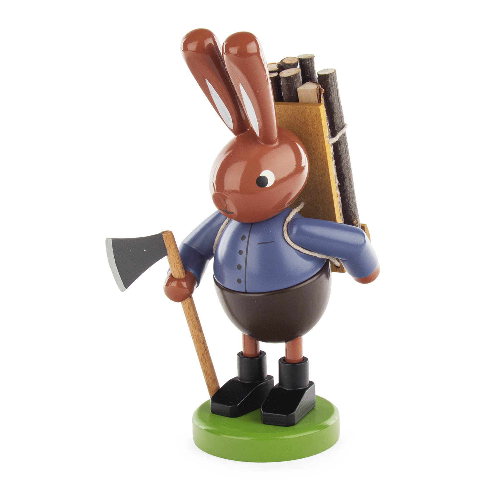 Holzfigur eines Hasen mit blauer Jacke, der auf einer grünen Basis steht. Der Hase trägt eine Holztrage voller Stöcke auf dem Rücken und hält eine Axt. im Dregeno Online Shop günstig kaufen