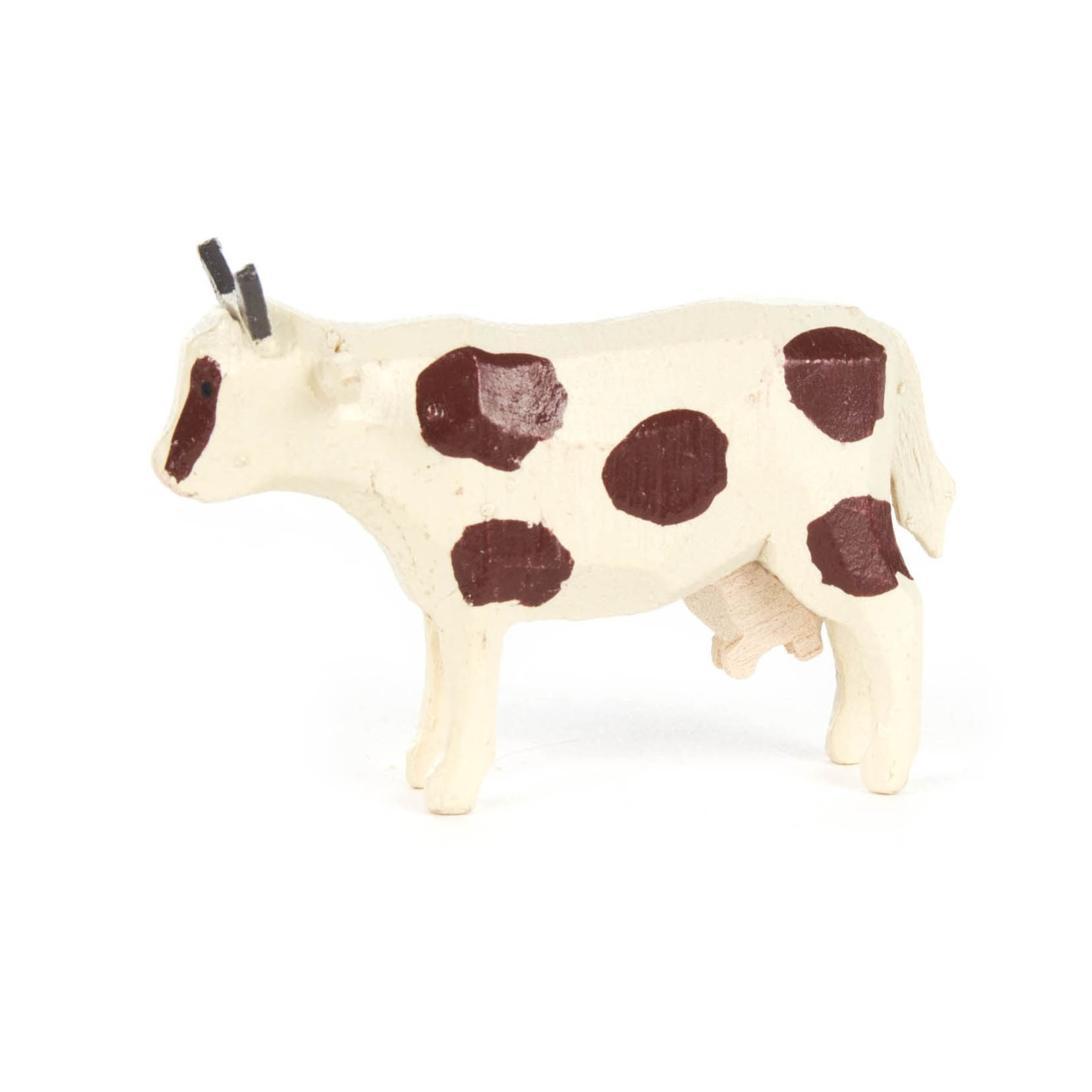 Ein Miniatur-Kuhmodell mit weißem Körper und braunen Flecken. Die Kuh hat kleine, gerade Hörner und einen Euter. im Dregeno Online Shop günstig kaufen