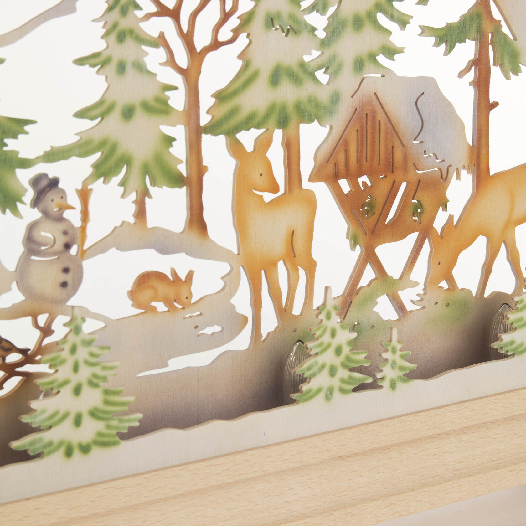Ornamental arch with woodland scene, featuring trees, deer, a rabbit, and a snowman, all illuminated with colored electric lights.