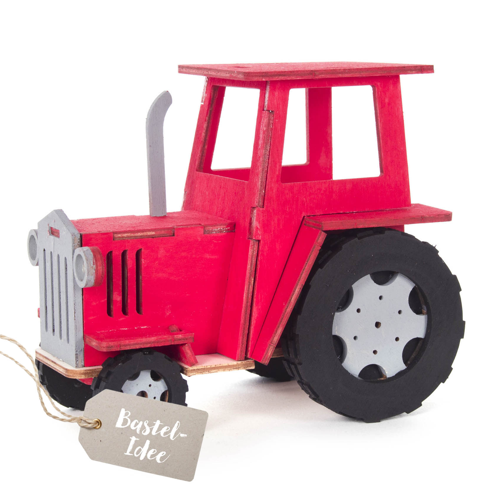 Holz-Bastelset eines roten Traktors mit schwarzem Fahrwerk und grauen Felgen auf einer Grundplatte. im Dregeno Online Shop günstig kaufen