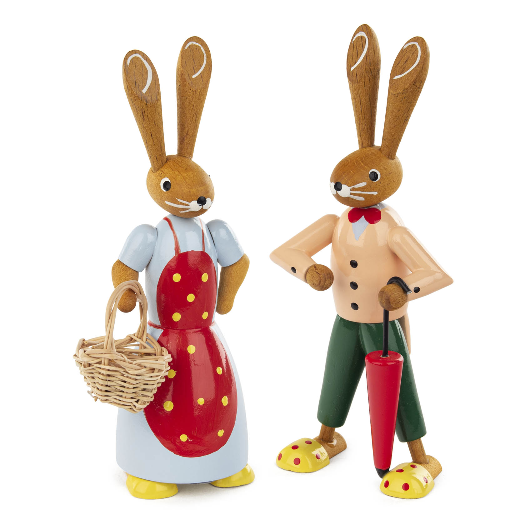 Zwei Holzfiguren von Hasen, einer trägt ein rotes Kleid mit weißen Punkten und hält einen Korb, der andere trägt eine Hose und hält einen Schirm. im Dregeno Online Shop günstig kaufen