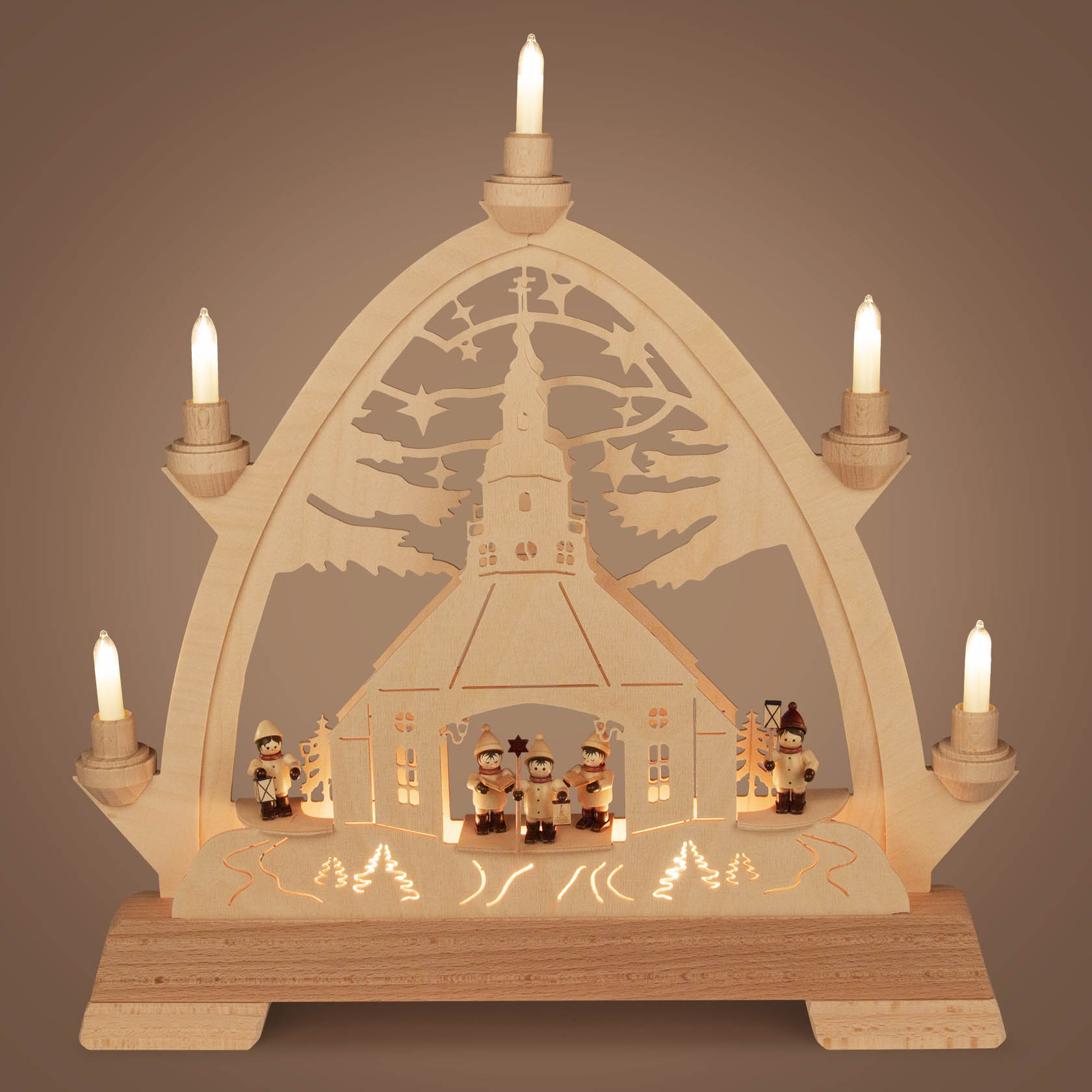 Holzbogen mit gotischem Design zeigt eine Seiffener Kirche mit Kurrende und Laternenkindern, beleuchtet von elektrischen Kerzen.