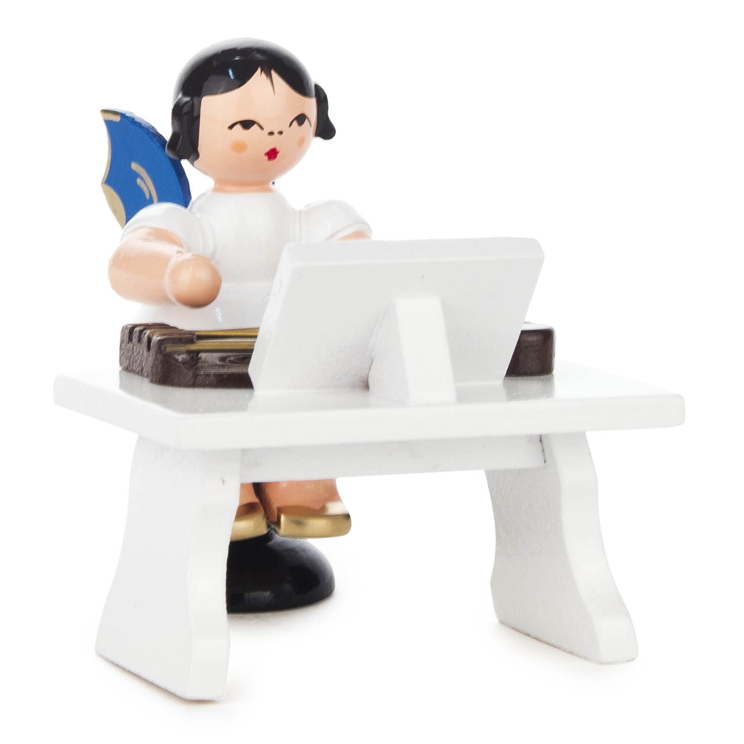 Holzfigur eines Engels mit schwarzen Haaren, blauen Flügeln und goldenen Schuhen, der an einem weißen Tisch sitzt und eine Zither spielt. im Dregeno Online Shop günstig kaufen