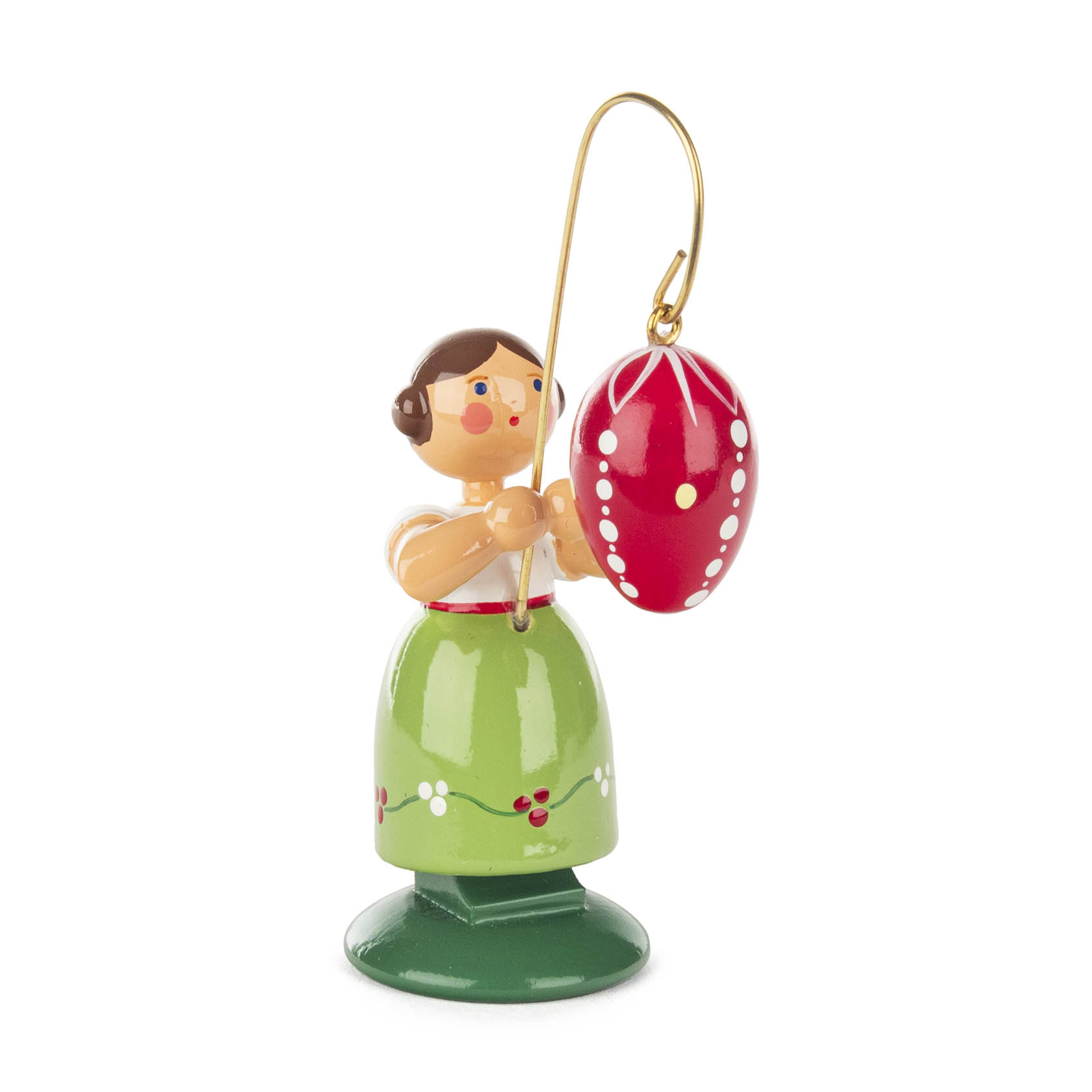 Holzfigur eines Mädchens mit braunen Haaren, grünem Rock und weißer Bluse, das ein großes rotes Osterei mit weißen Verzierungen in die Höhe hält. im Dregeno Online Shop günstig kaufen