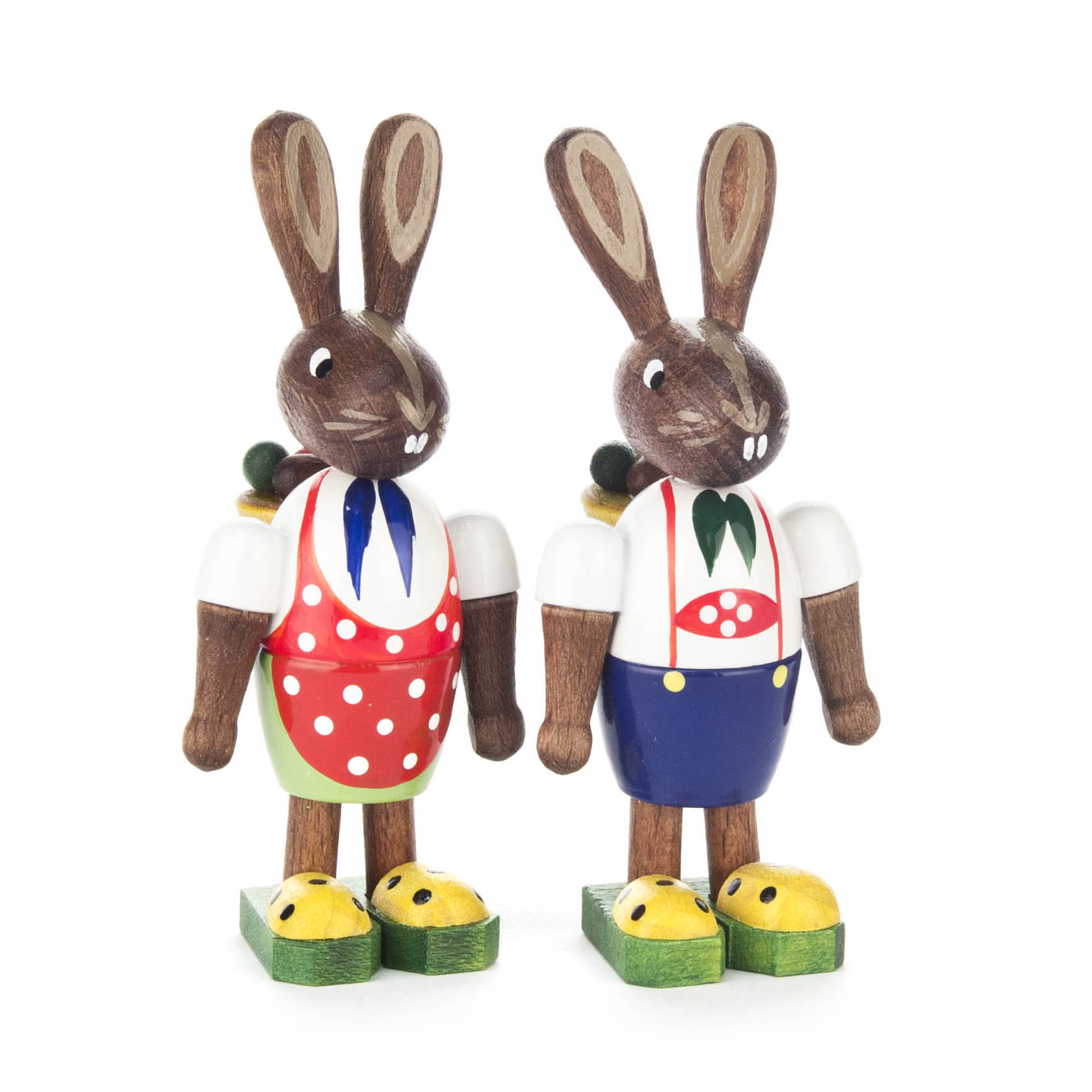 Zwei hölzerne Hasenfiguren, beide tragen Körbe auf dem Rücken. Der linke Hase hat eine rote Schürze mit weißen Punkten, der rechte Hase eine mit einem Latz mit grünen Punkten. im Dregeno Online Shop günstig kaufen