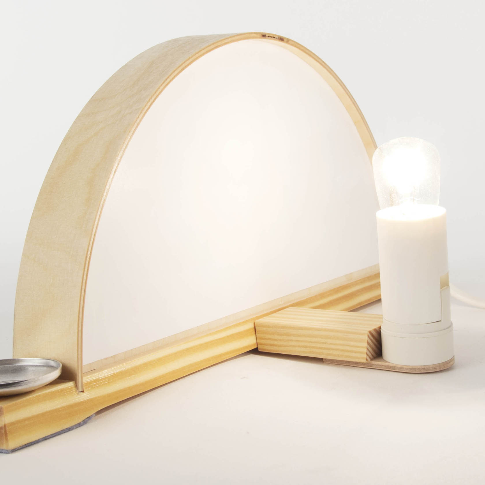 Moderner Schwibbogen aus hellem Holz, schlichtes Design ohne Verzierungen, auf einer Seite eine weiße Leuchte, die das Innere beleuchtet.