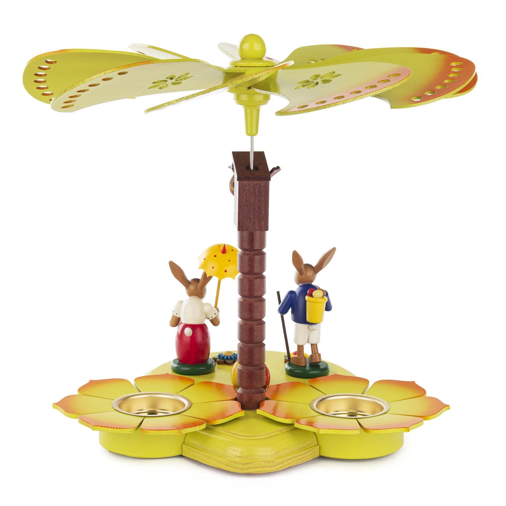 Teelichtpyramide in gelb-grün, zwei Hasenfiguren mit Schirm und Kiepe, hölzerne Flügel oben, zwei Teelichthalter im unteren Bereich.