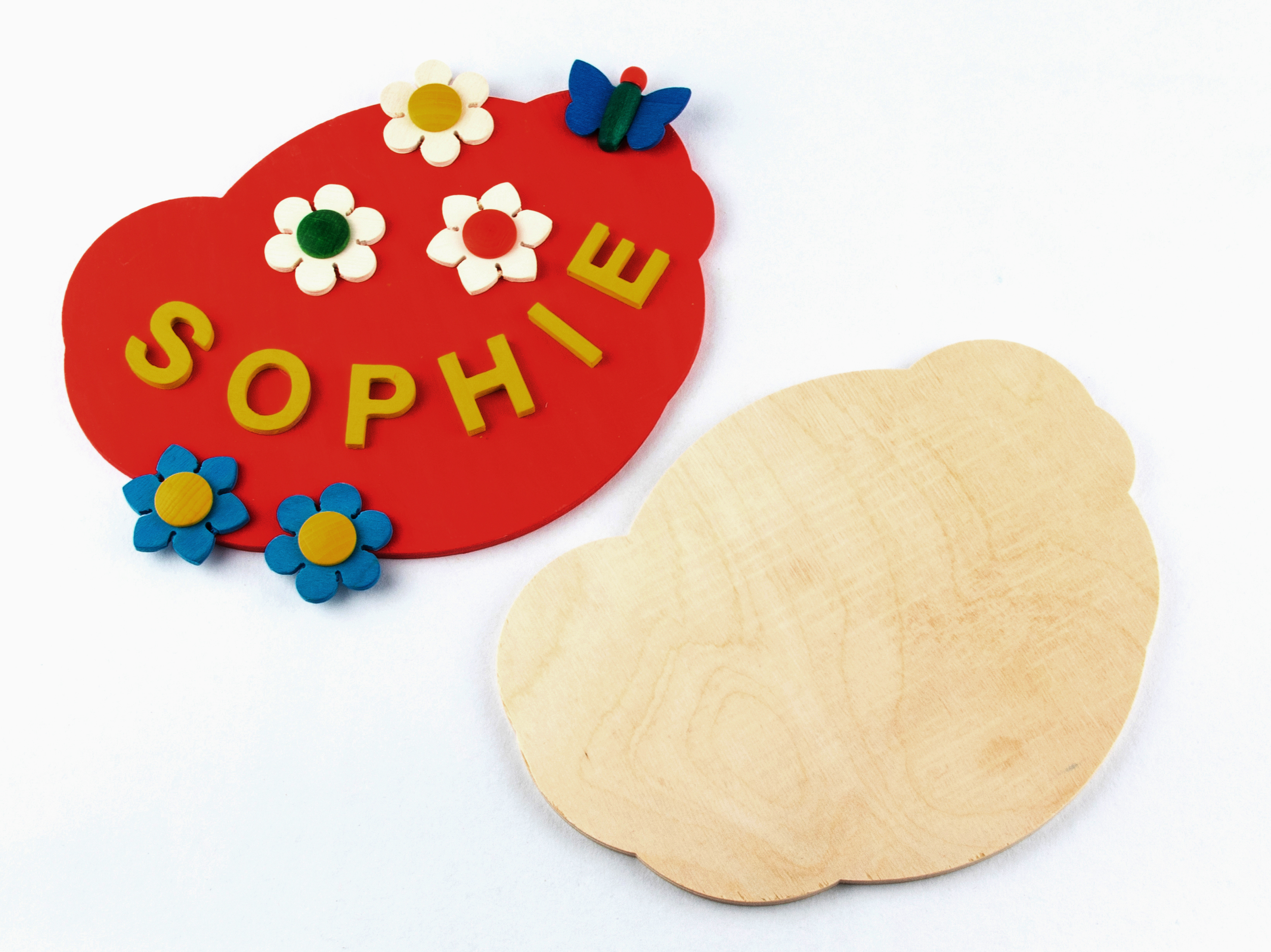 Eine rote Wolken-Holzplatte mit dem Namen 'Sophie', Blumen und Schmetterlingsdekoration sowie eine unbehandelte Holzplatte in Wolkenform. im Dregeno Online Shop günstig kaufen