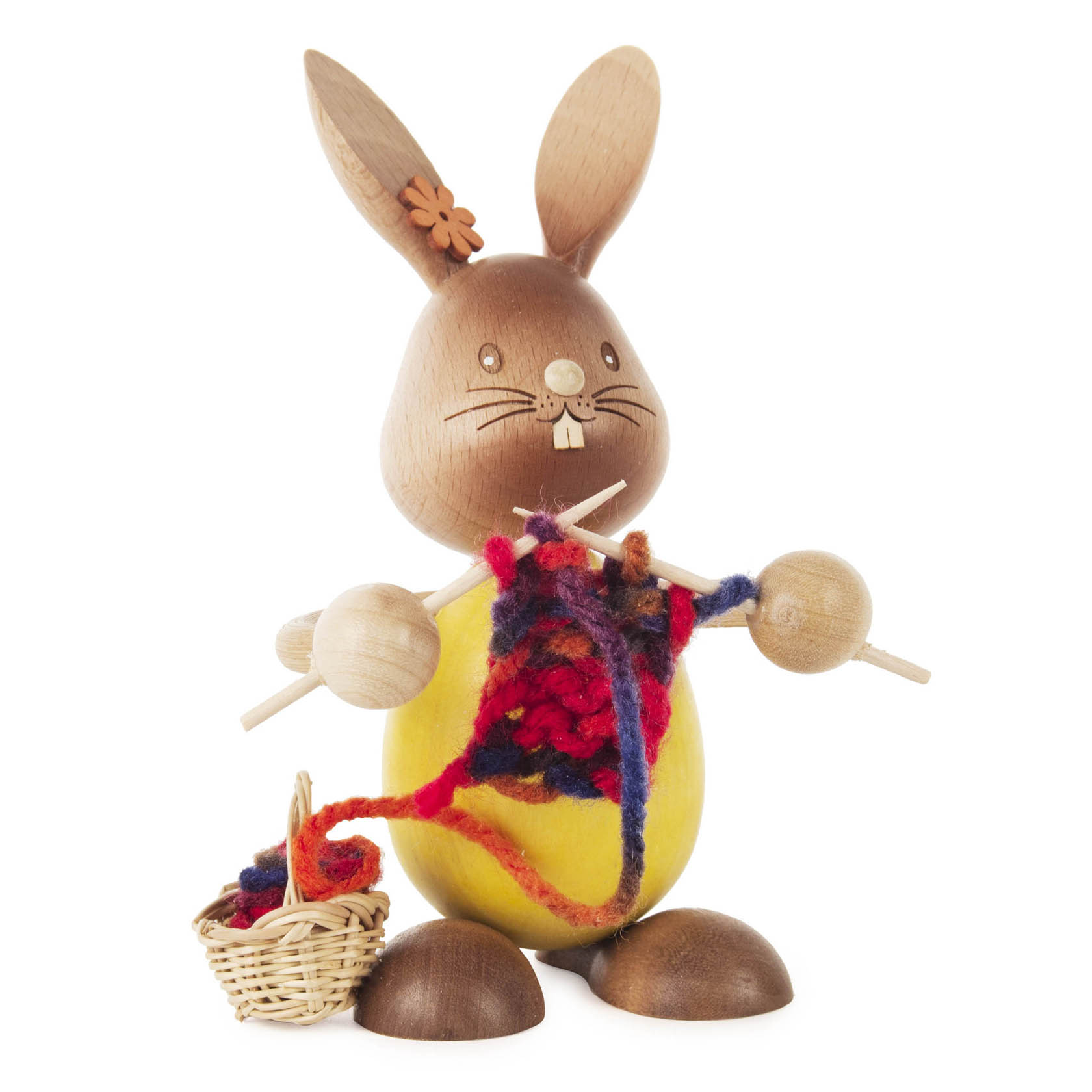 Holzfigur eines Hasen namens Stupsi, der ein Strickstück mit buntem Garn und Stricknadeln hält, daneben ein kleiner Korb mit Garn. im Dregeno Online Shop günstig kaufen
