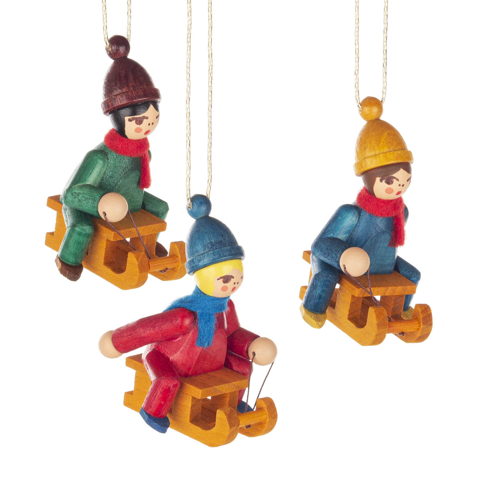 Drei bunte Holzfiguren von Kindern, die auf Schlitten sitzen, tragen Winterkleidung mit Mützen und Schals, und hängen an goldenen Schnüren. im Dregeno Online Shop günstig kaufen