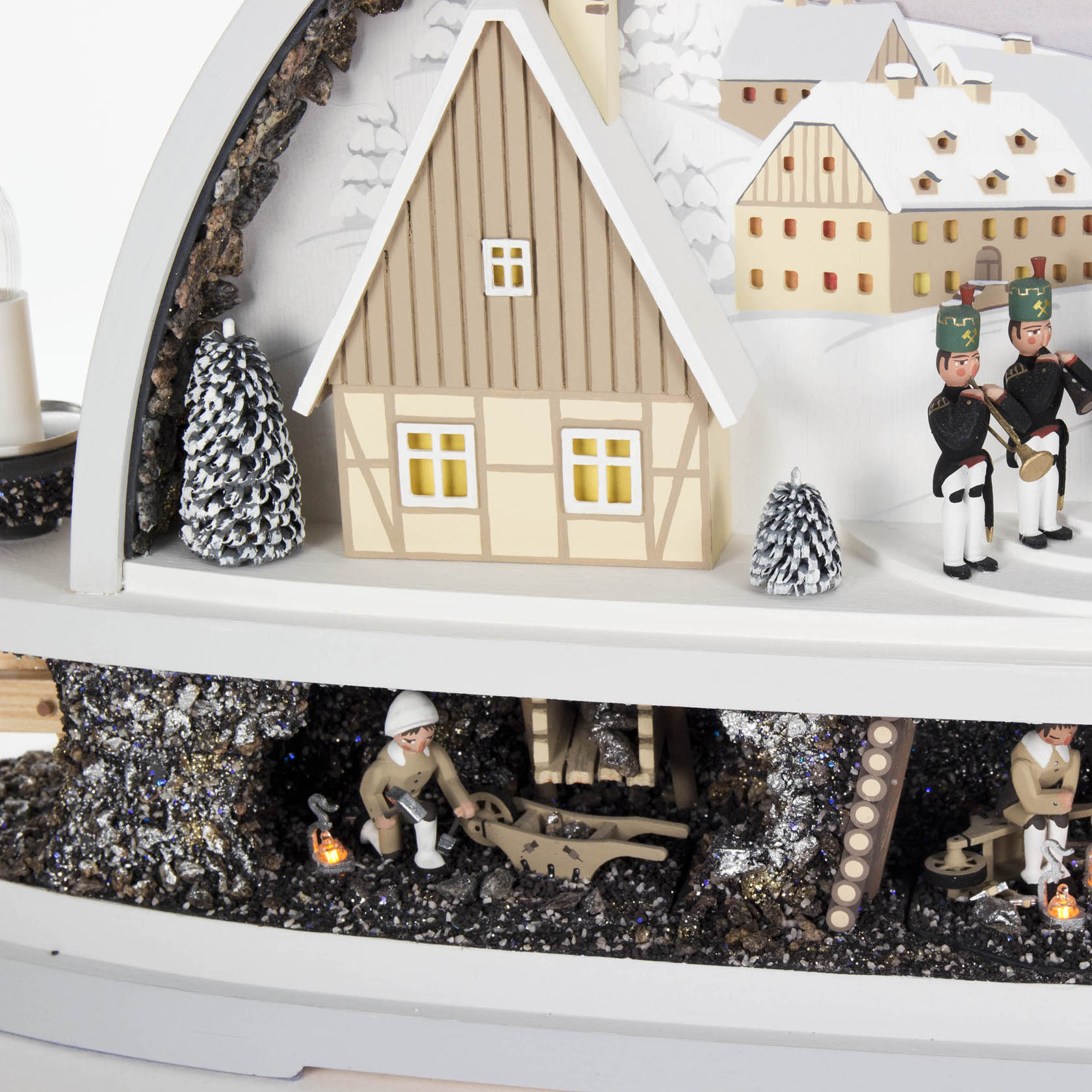 Illuminated wooden arch with Seiffen village, miner chapel, and mine. Features figurines of miners and traditional architecture.