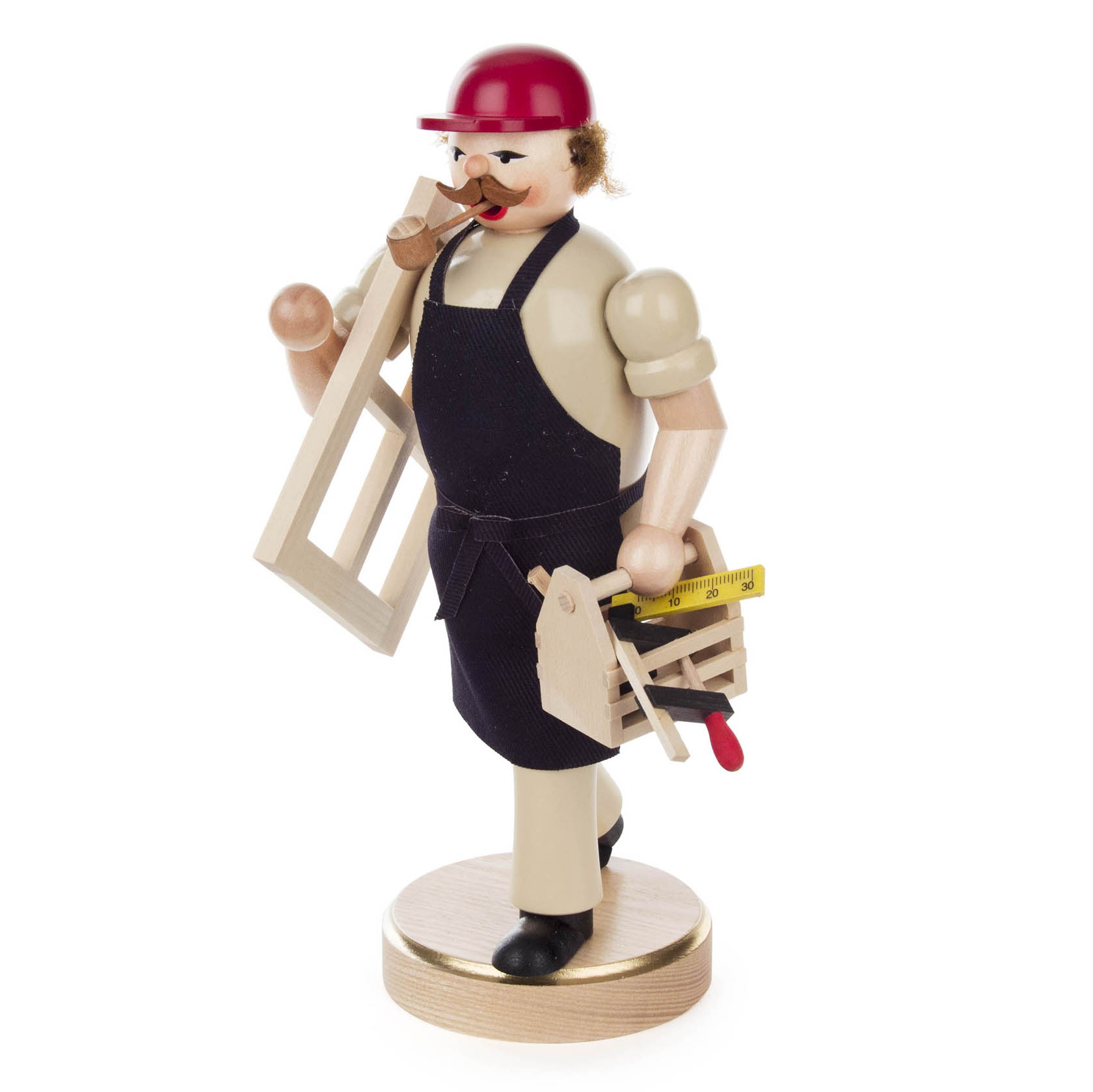 Holzfigur eines Tischlers mit rotem Schutzhelm, Pfeife im Mund, schwarzer Schürze und Werkzeugen wie einer Säge und einem Maßband in den Händen.