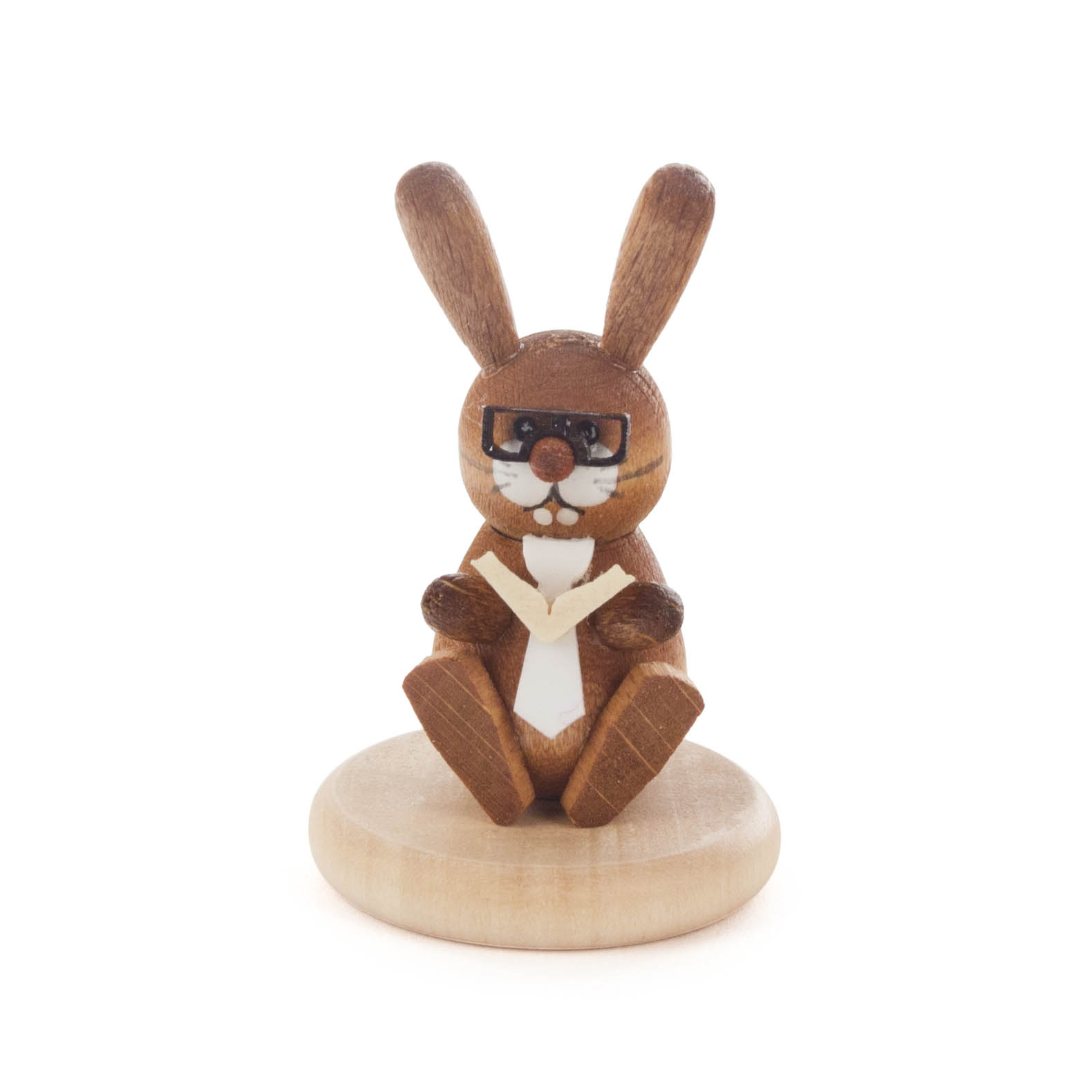 A wooden, painted rabbit figurine with glasses sitting on a base, holding a book.