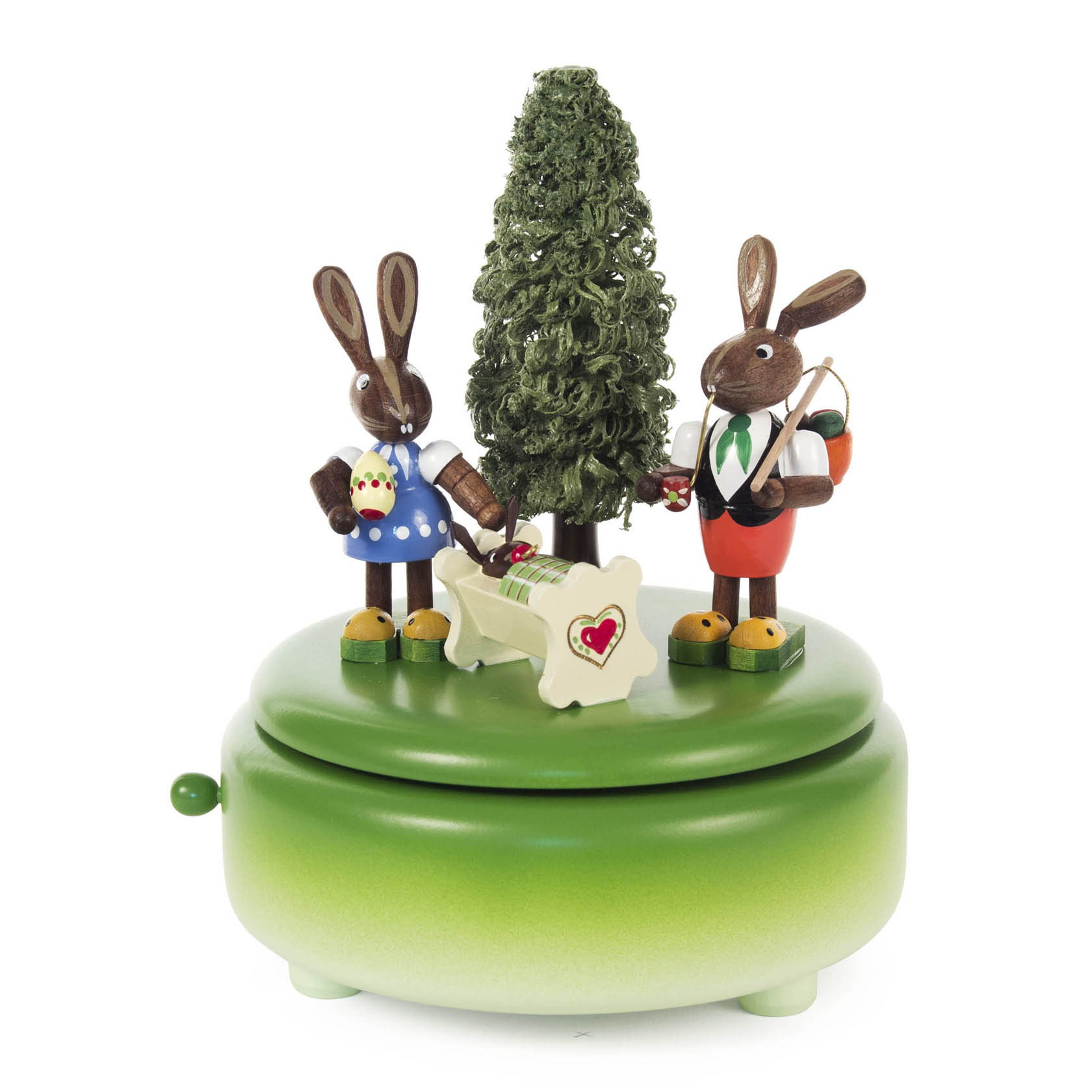 Zwei Osterhasenfiguren stehen auf einer grünen Spieldose. Eine Häsin trägt einen blauen Rock und hält Eier, der Hase eine Trommel. Eine Wiege mit Herz ist in der Mitte. im Dregeno Online Shop günstig kaufen