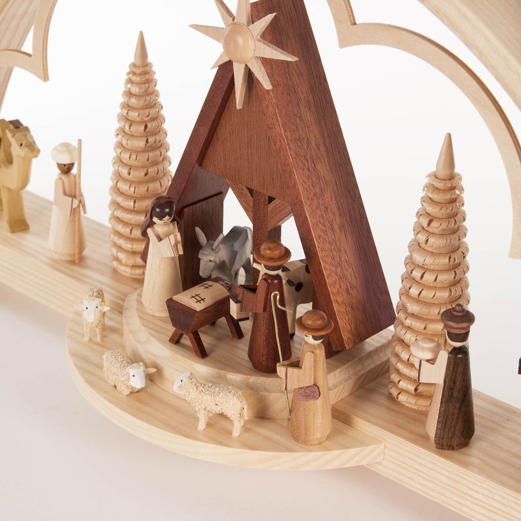 A wooden illuminated Christmas arch (Schwibbogen) featuring a nativity scene with Mary, Joseph, baby Jesus, shepherds, and animals.
