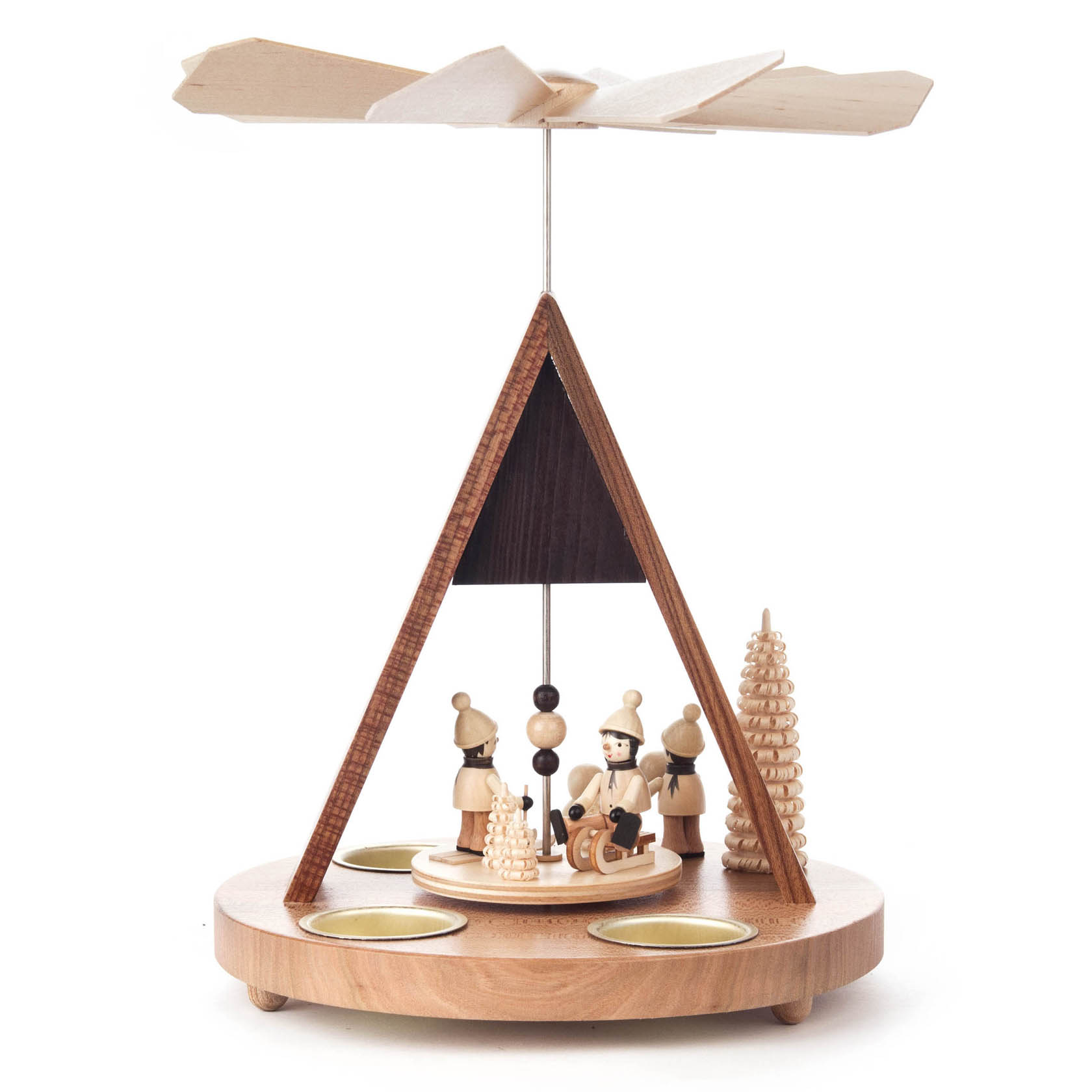 Holzpyramide mit einem Dreiecksdach, darunter drei geschnitzte Winterkinder und ein Baum, umgeben von Haltern für Teelichte.