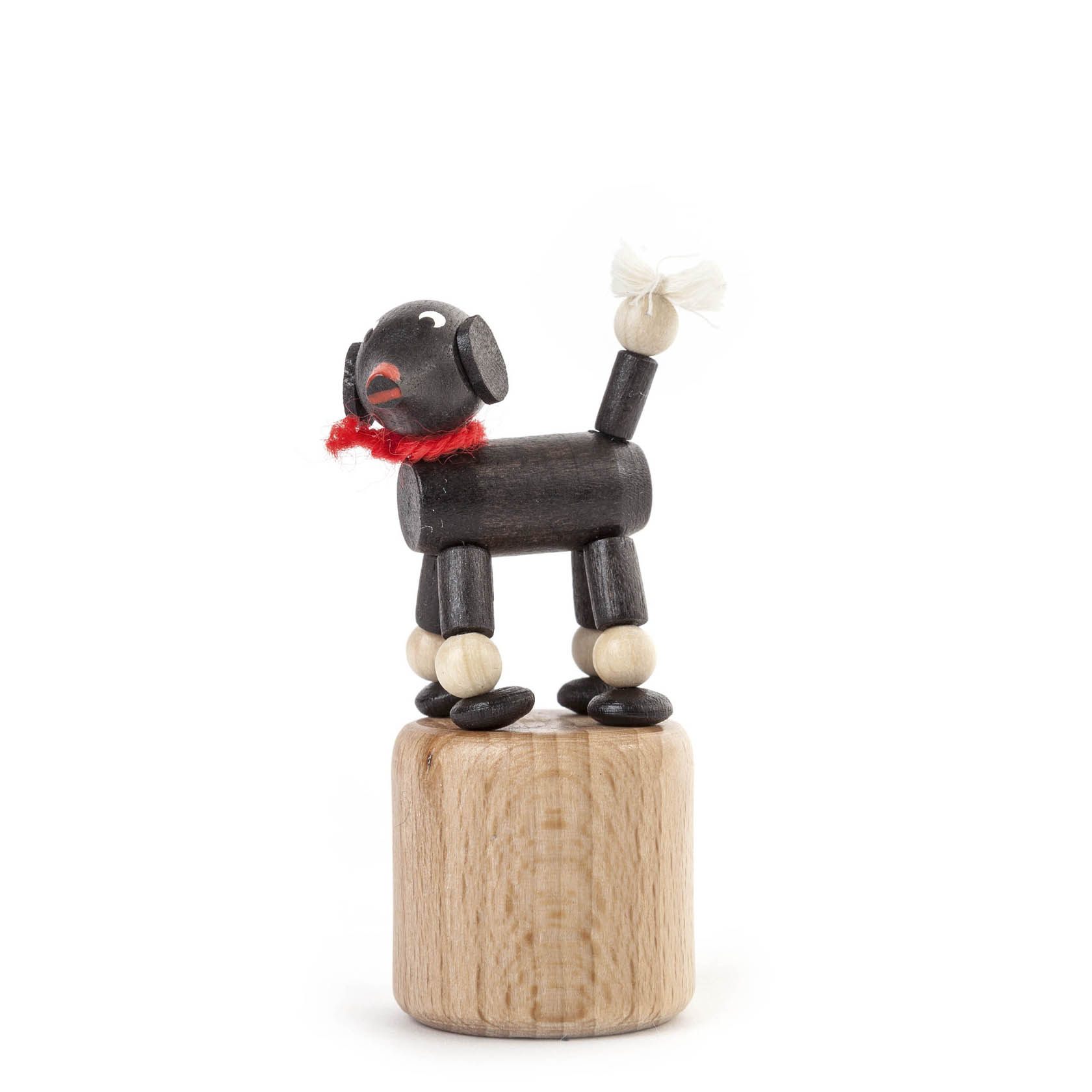 Ein Wackeltier in Form eines schwarzen Pudels, aus Holz gefertigt. Der Pudel trägt einen roten Schal und steht auf einer runden Holzplattform. im Dregeno Online Shop günstig kaufen