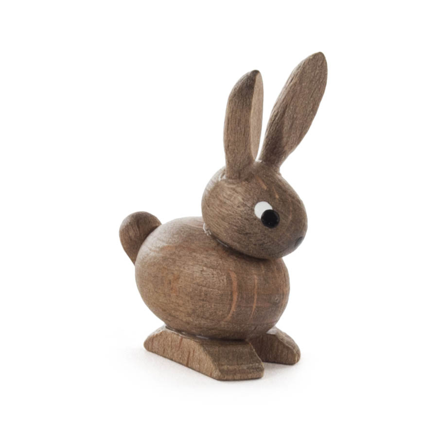 Eine kleine Holzfigur eines Hasen mit aufrechtem Körper, langen Ohren und aufgemalten Augen, stehend auf vier kurzen Beinen. im Dregeno Online Shop günstig kaufen