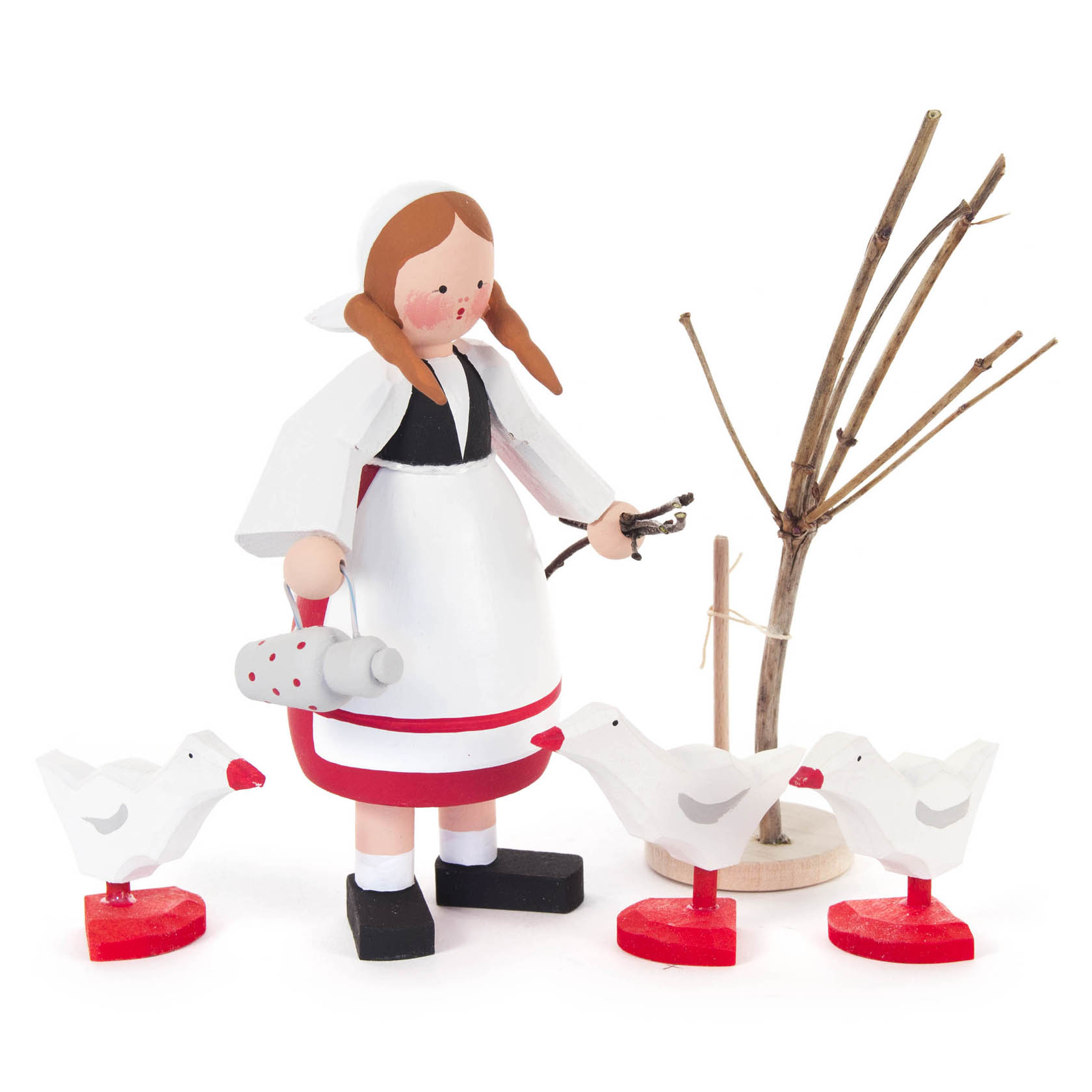 Holzfigur einer jungen Frau mit Kopftuch, in weißem Gewand, hält eine Gans in der linken Hand. Vor ihr stehen zwei weitere geformte Holzgänse, ein kahler Ast ist im Hintergrund. im Dregeno Online Shop günstig kaufen