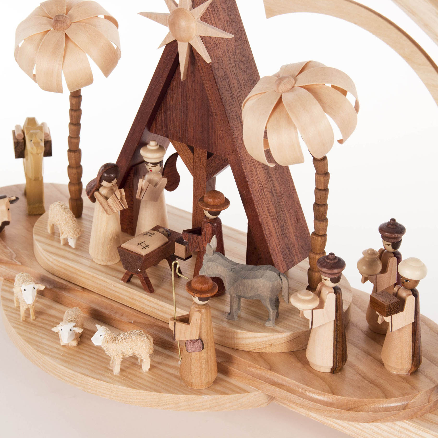 Ein Holz-Schwibbogen mit der Darstellung der Geburt Christi. Zu sehen sind Maria, Josef, Jesus in der Krippe, Hirten, Schafe, Esel und Palmen.