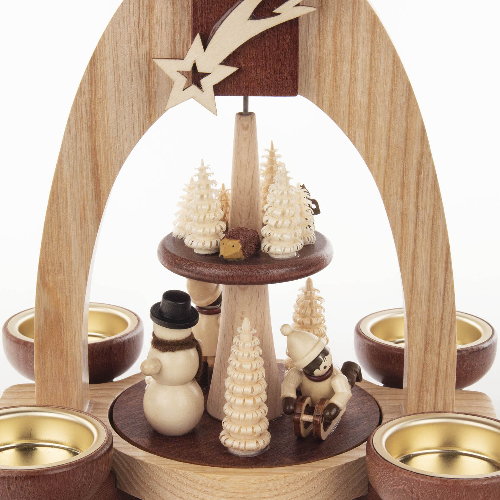 Holzpyramide mit zwei Ebenen, verziert mit Schneemännern und Kindern im Winter, umgeben von dekorativen Bäumen und Teelichthaltern.