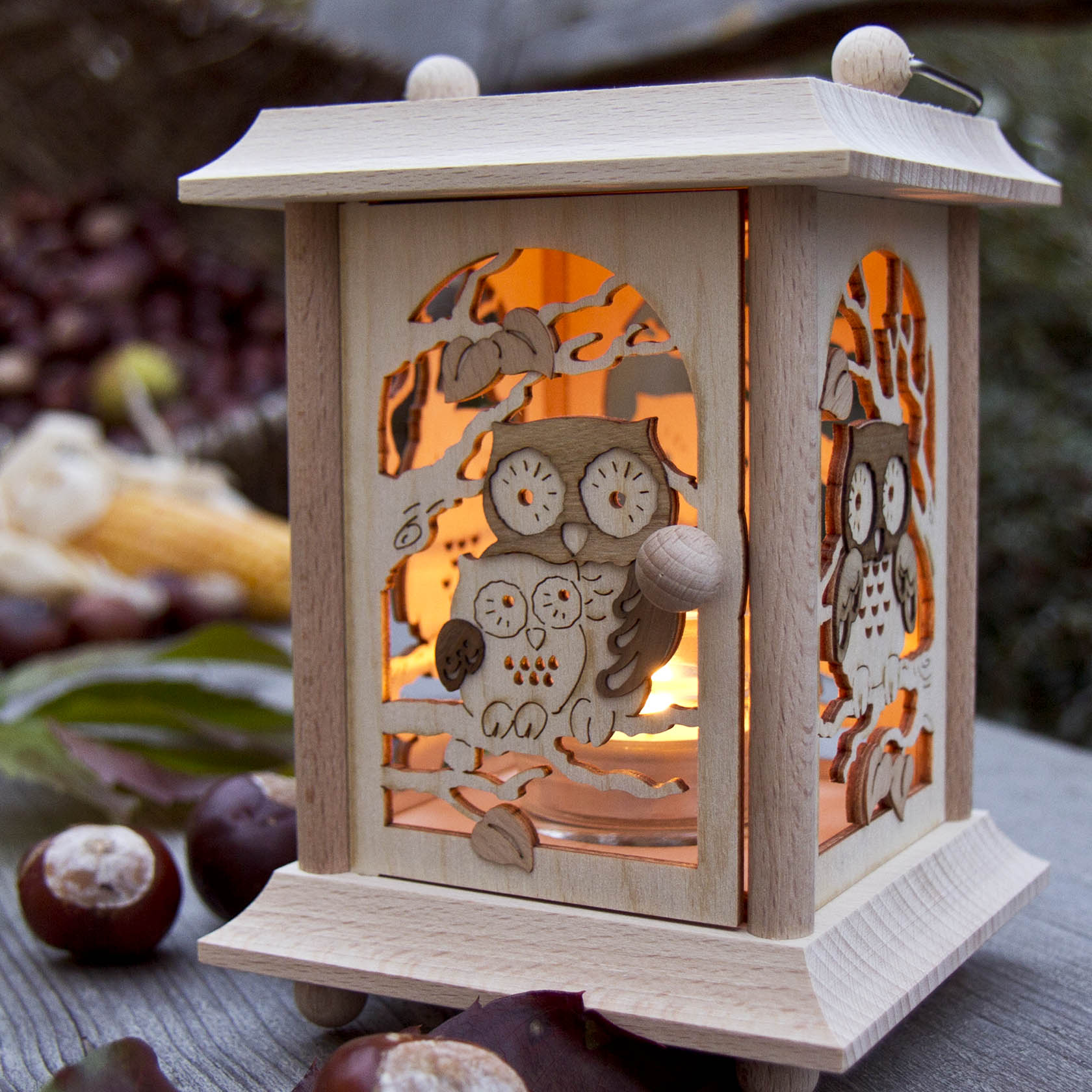 Holzlaterne mit Eulenmotiven und Glaseinsatz für Teelicht, beleuchtet von innen. Dekorative Eulen mit ausgeschnittenem Design auf allen Seiten.