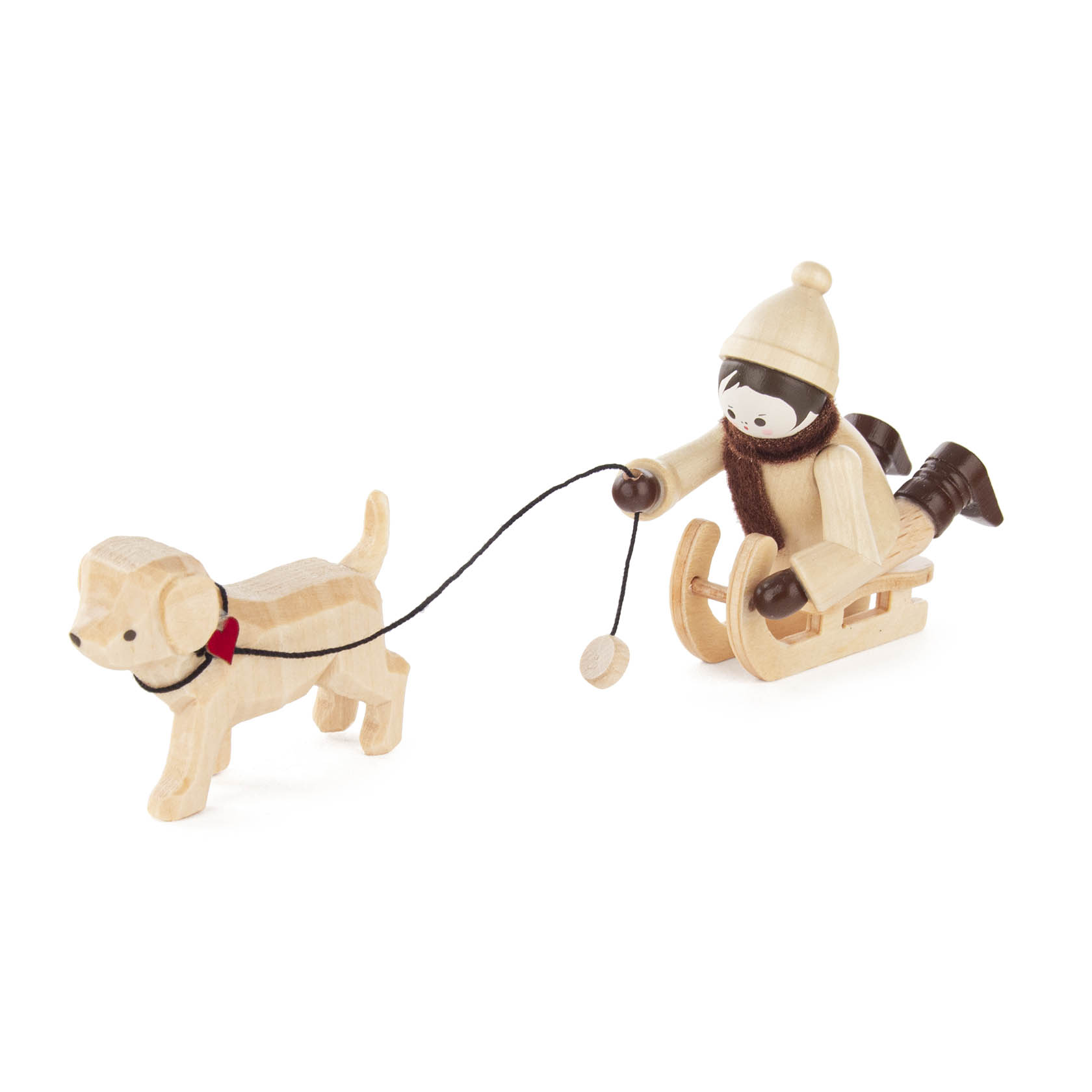 Holzfigur eines Jungen mit Wintermütze und Schal sitzt auf einem Schlitten, der von einem kleinen Holzhund mit rotem Halsband gezogen wird. im Dregeno Online Shop günstig kaufen