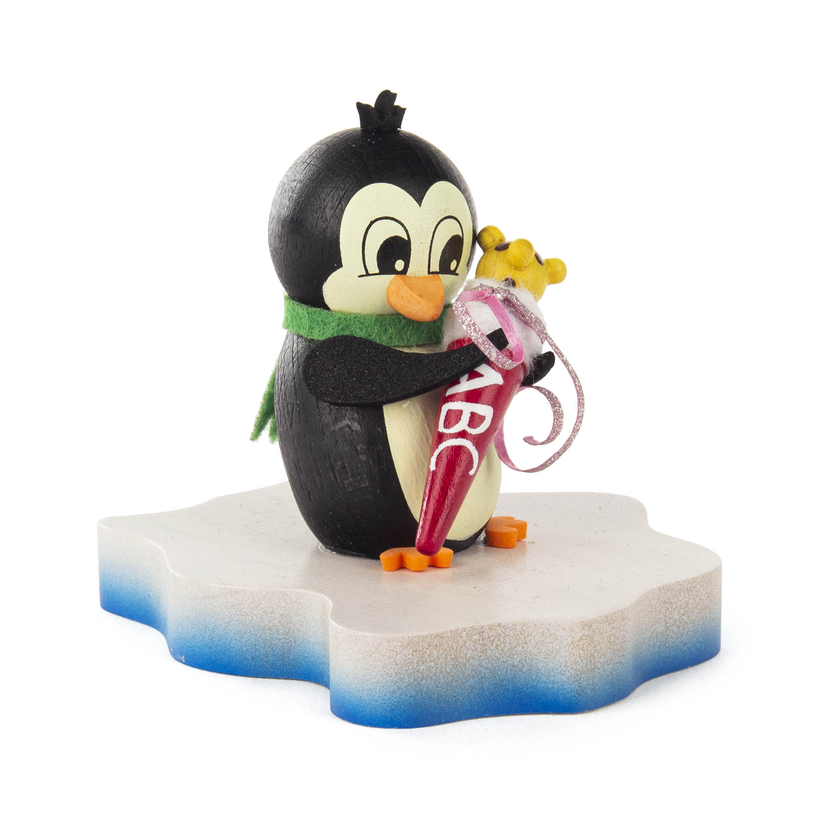 Ein niedlicher, schwarz-weißer Pinguin mit grünem Schal hält eine rote Zuckertüte, die mit einem Band verziert ist, auf einer eisähnlichen Plattform. im Dregeno Online Shop günstig kaufen