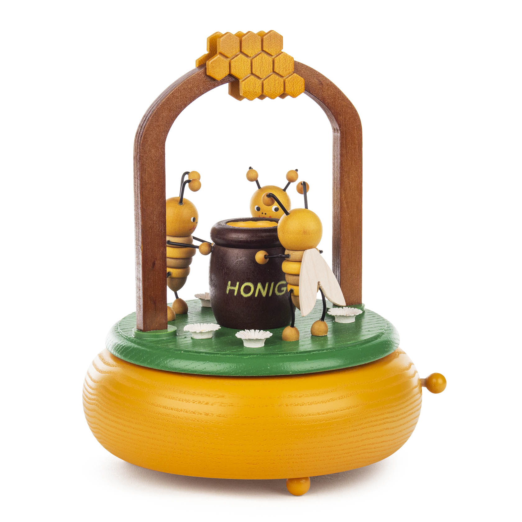 Spieldose in Form einer Bienenwiese mit drei Bienenfiguren, die um einen Honigtopf tanzen. Der Sockel ist bienenwabenförmig.