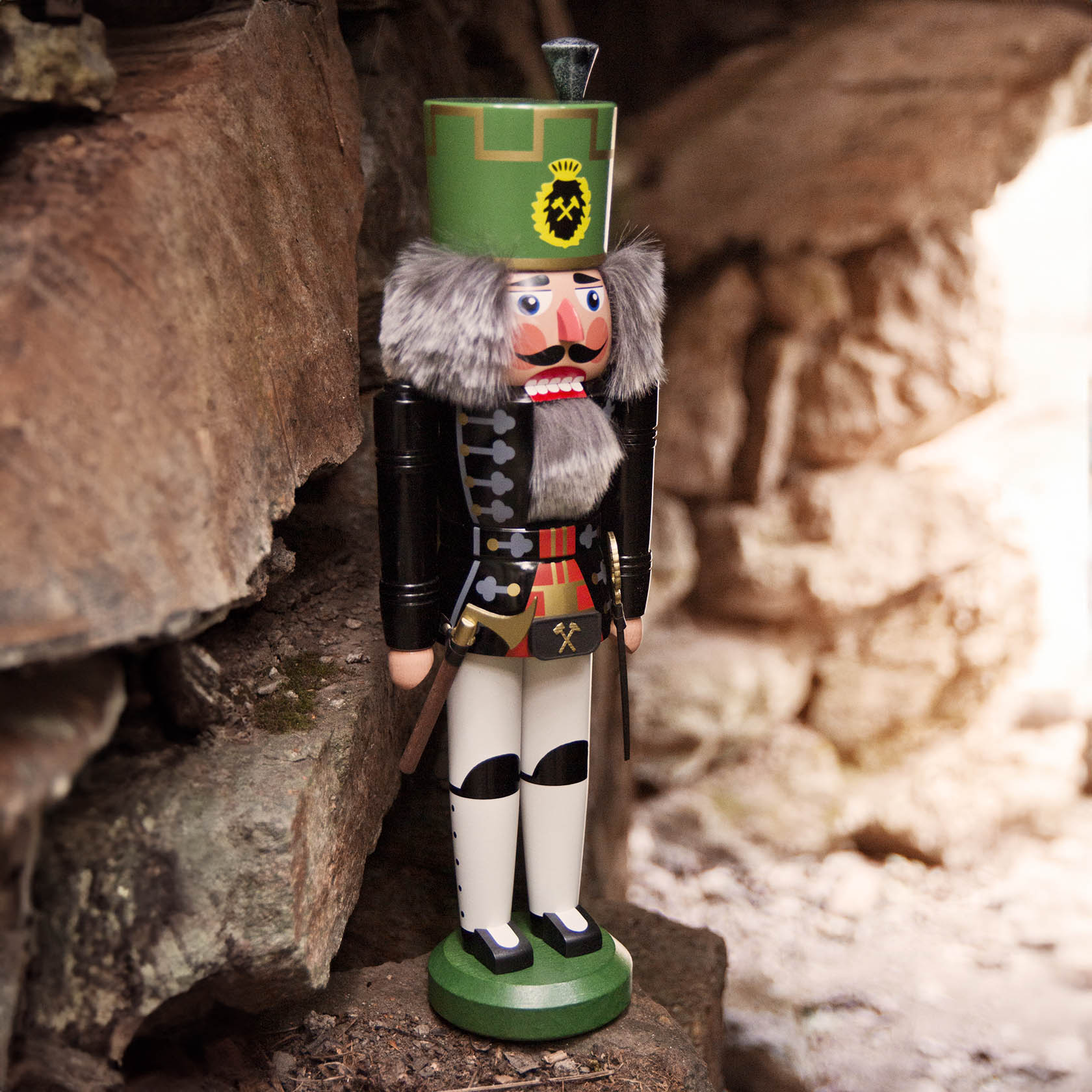 Ein traditioneller Nussknacker in der Form eines schwarz-weiß gekleideten Bergmanns, genannt Knappschaftsältester, mit detaillierter Uniform und grünem Hut.