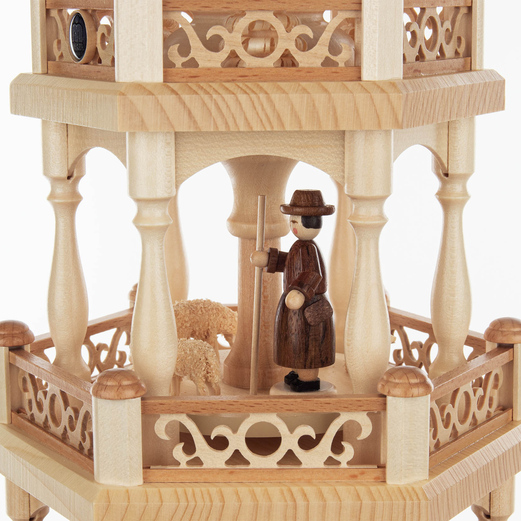 Zweistufige Holzpyramide mit geschnitzter Figur, die eine Waldperson darstellt, und zwei Schafen. Elektrische Beleuchtung ist integriert.
