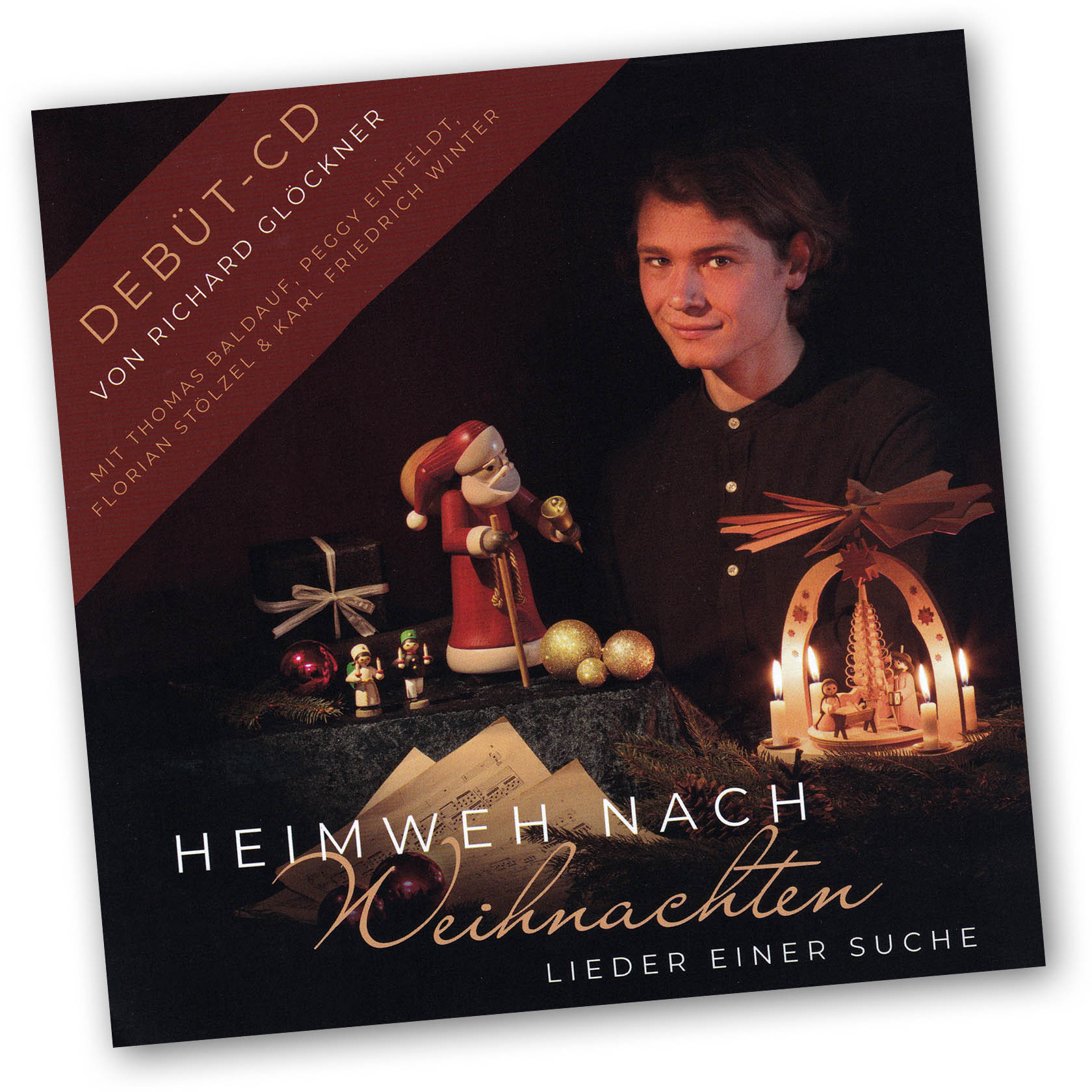 Young man with a candle-lit table, holding a Santa figurine, featuring a wooden Christmas pyramid and Christmas decorations in the background. im Dregeno Online Shop günstig kaufen