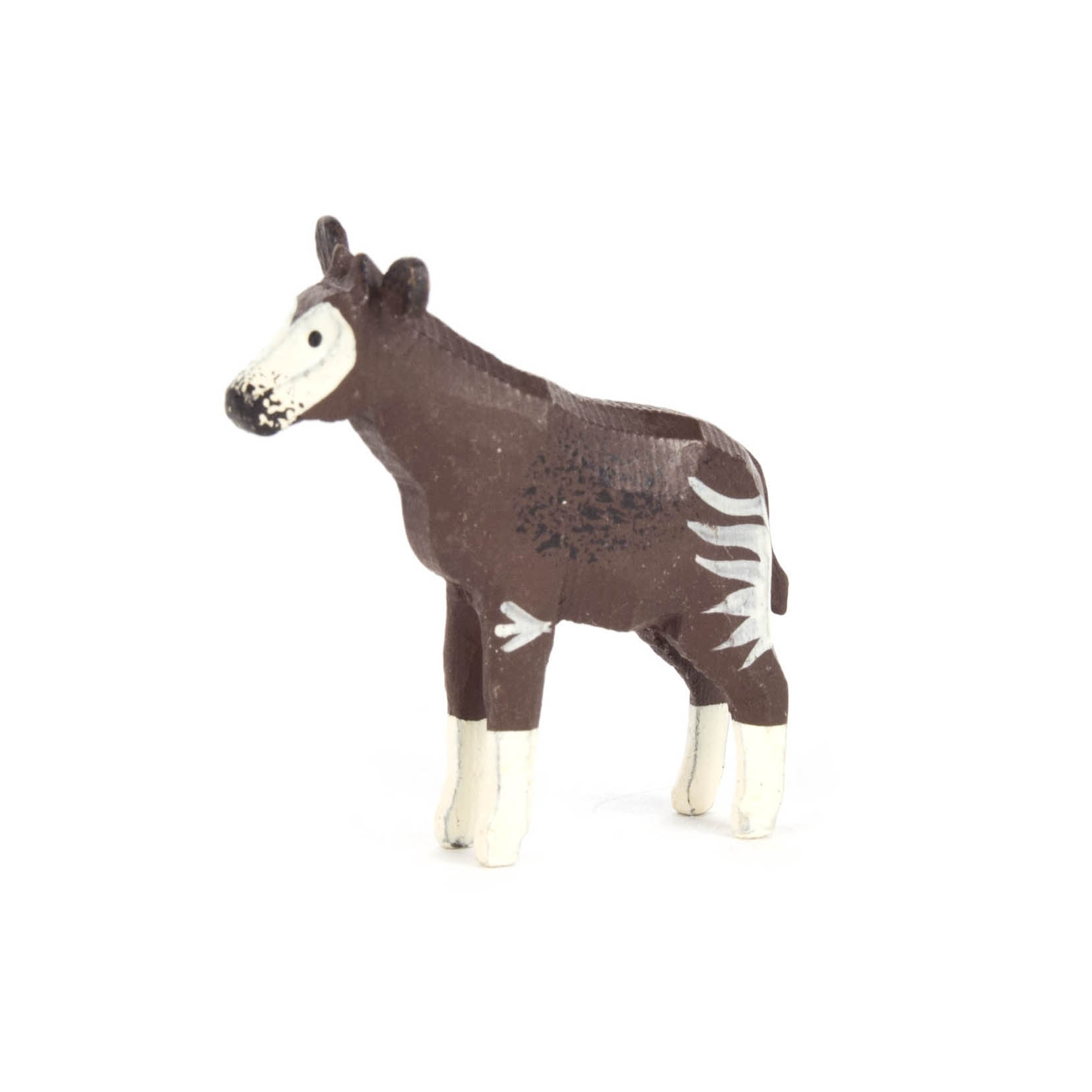 Kleine Plastikfigur eines Okapis, brauner Körper mit weißen Streifen an Beinen und Gesicht, stehend auf weißen Beinen. im Dregeno Online Shop günstig kaufen